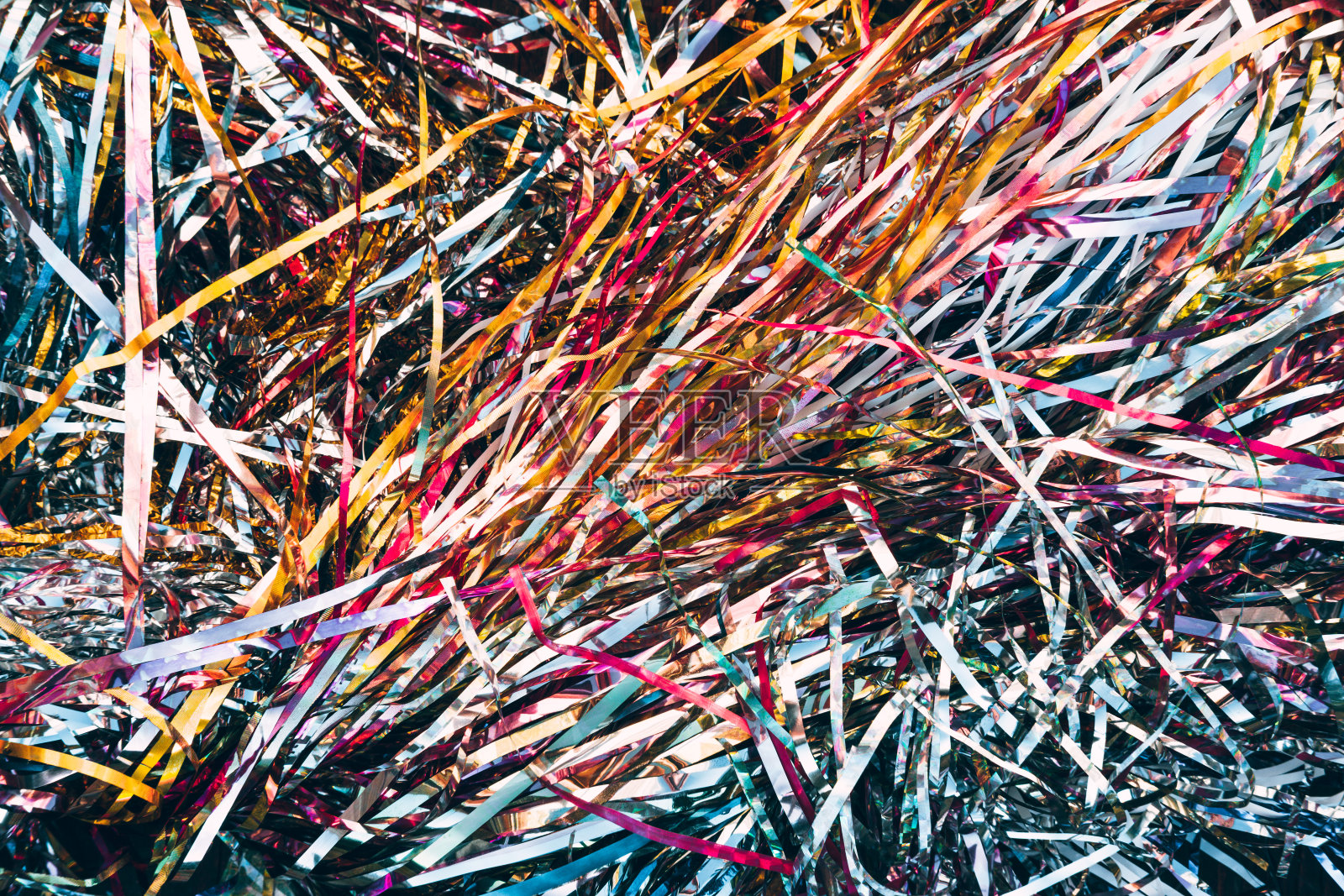 美丽的圣诞背景在水平格式。新年的多彩闪亮的雨特写。圣诞装饰品，色彩鲜艳的金箔。照片摄影图片