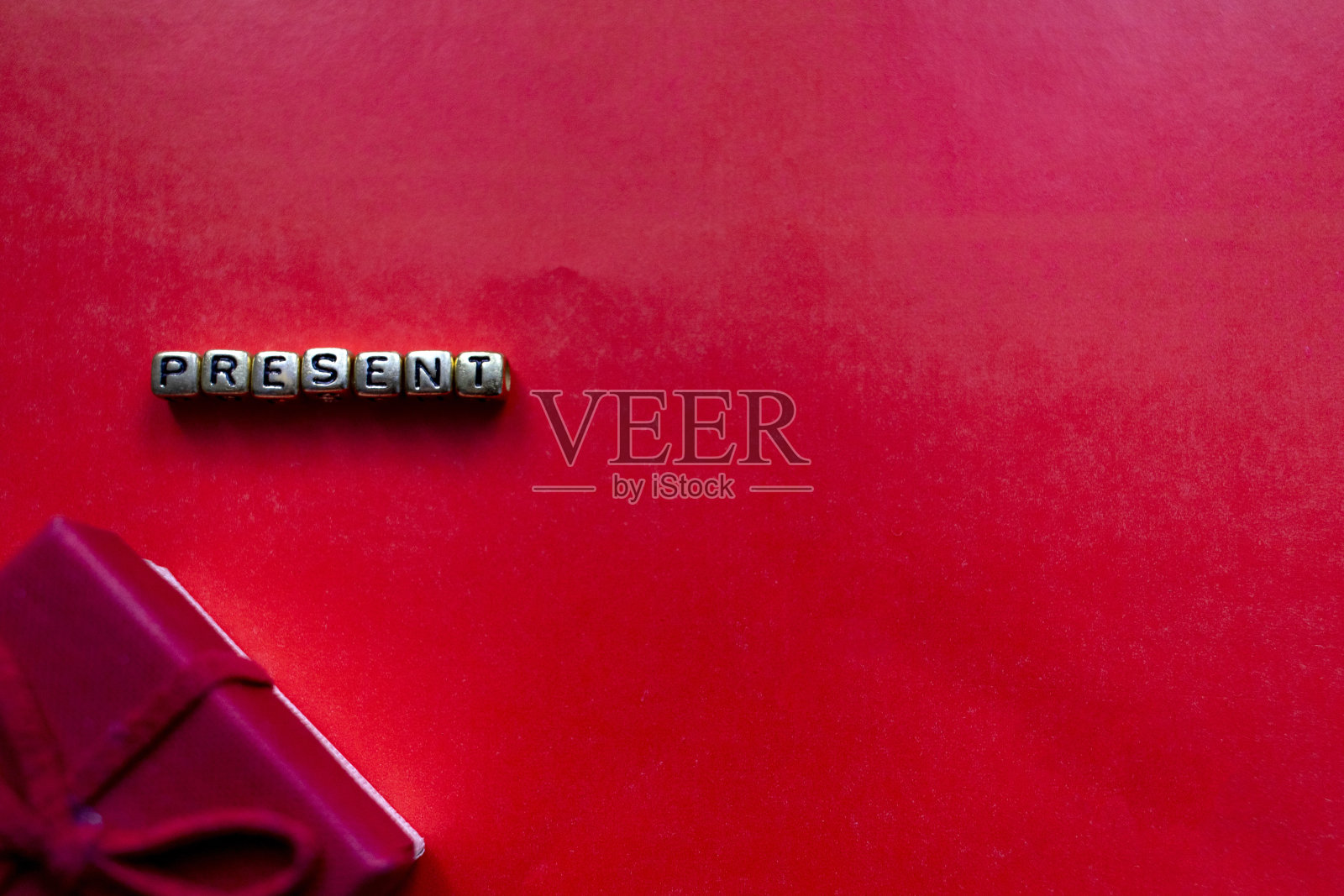 现在的概念。新年礼物以红色为背景。圣诞作文在一个红色的背景与题词在金字礼物。带有文本位置的俯视图照片摄影图片