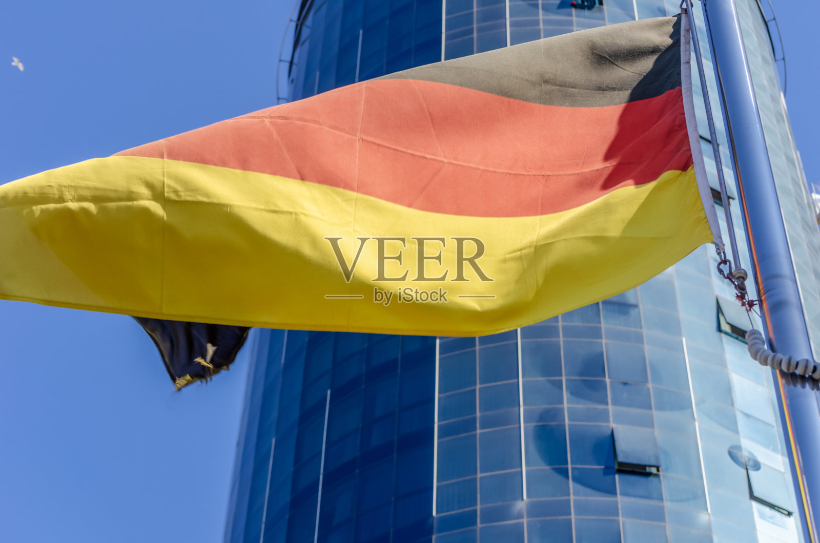 德国国旗背景的现代玻璃建筑和蓝天特写照片摄影图片