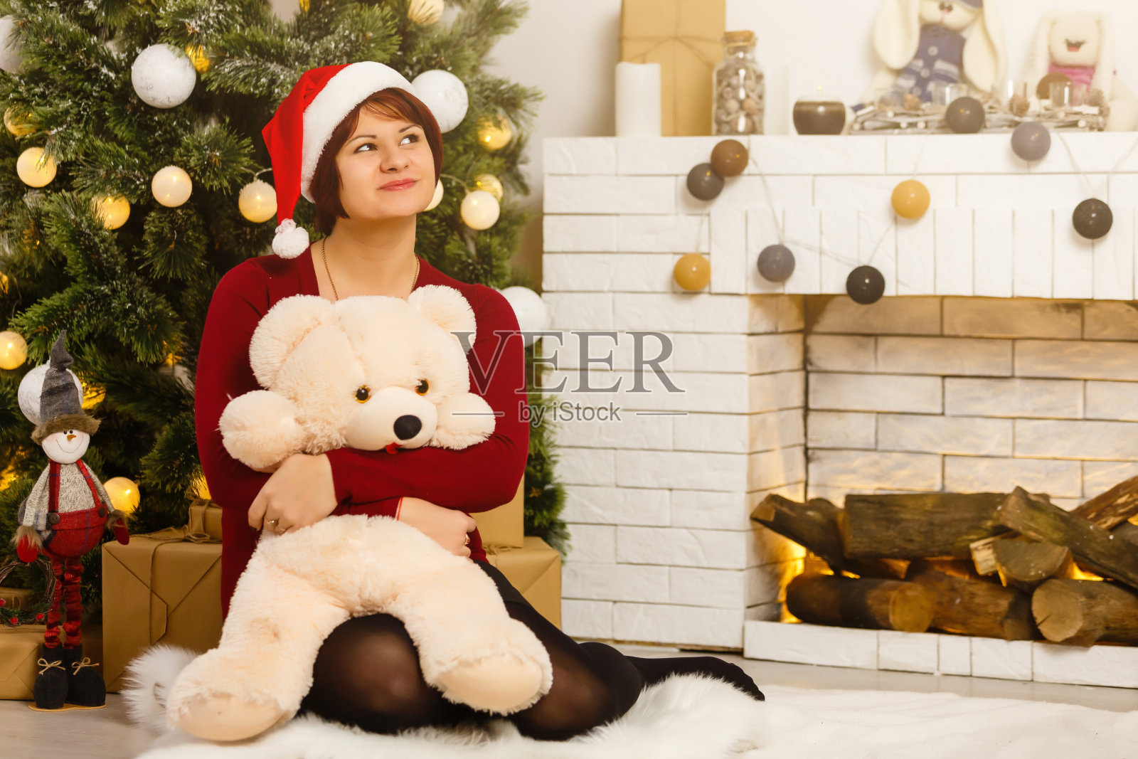 圣诞节到了，戴着圣诞帽的女孩收到了圣诞礼物照片摄影图片