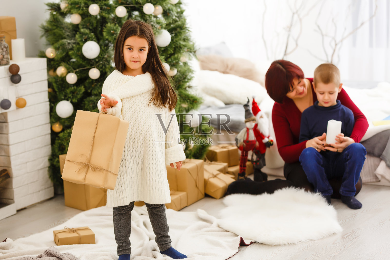 一个小圣诞女孩打开了一份圣诞礼物，惊讶不已照片摄影图片