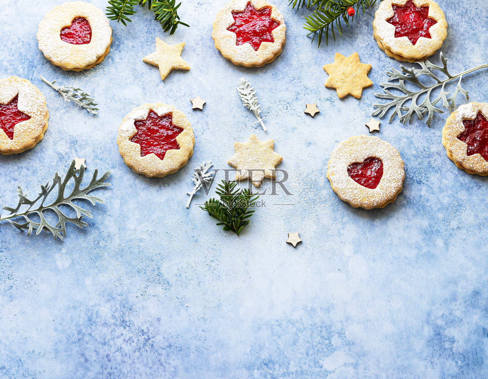 林泽圣诞或新年饼干填满果酱，并撒上糖粉在蓝色的石头背景。传统的奥地利圣诞饼干。节日装饰。前视图。照片摄影图片
