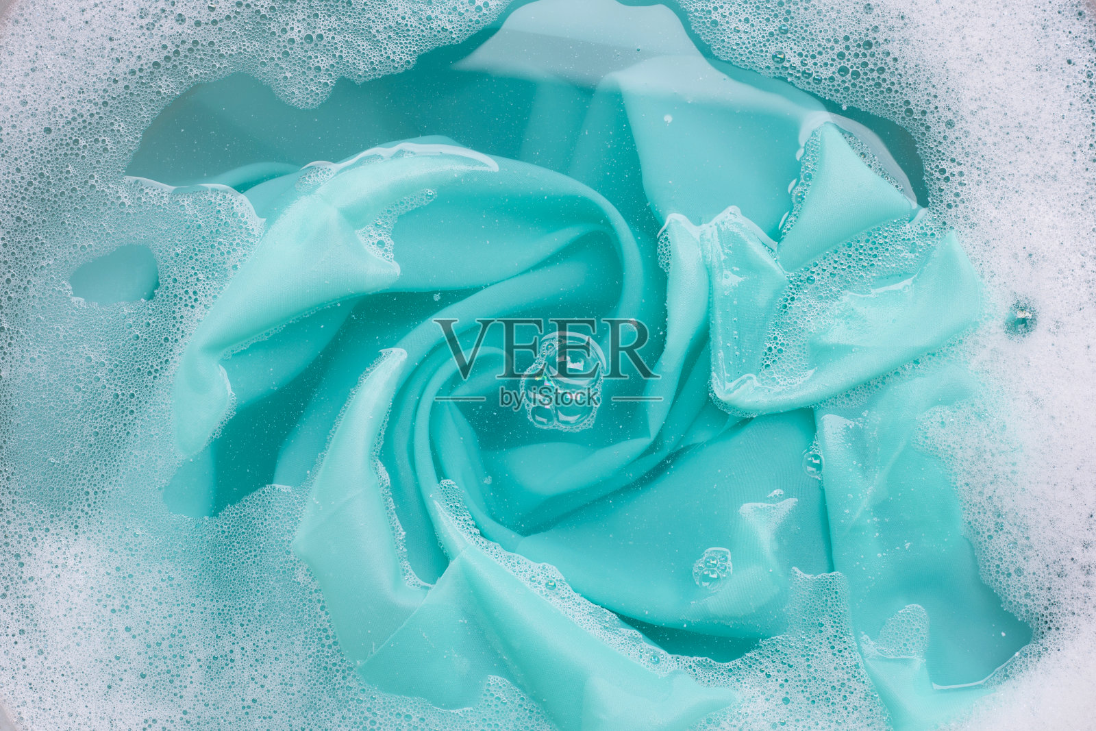 颜色衣服浸泡在洗衣粉水溶解。衣服的概念照片摄影图片