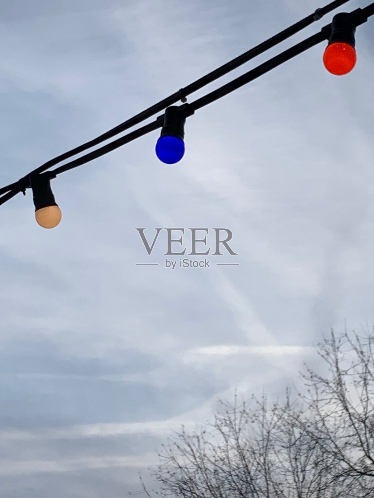 以低角度拍摄的彩色圣诞灯挂在一根缆绳上的山区景观背景照片摄影图片