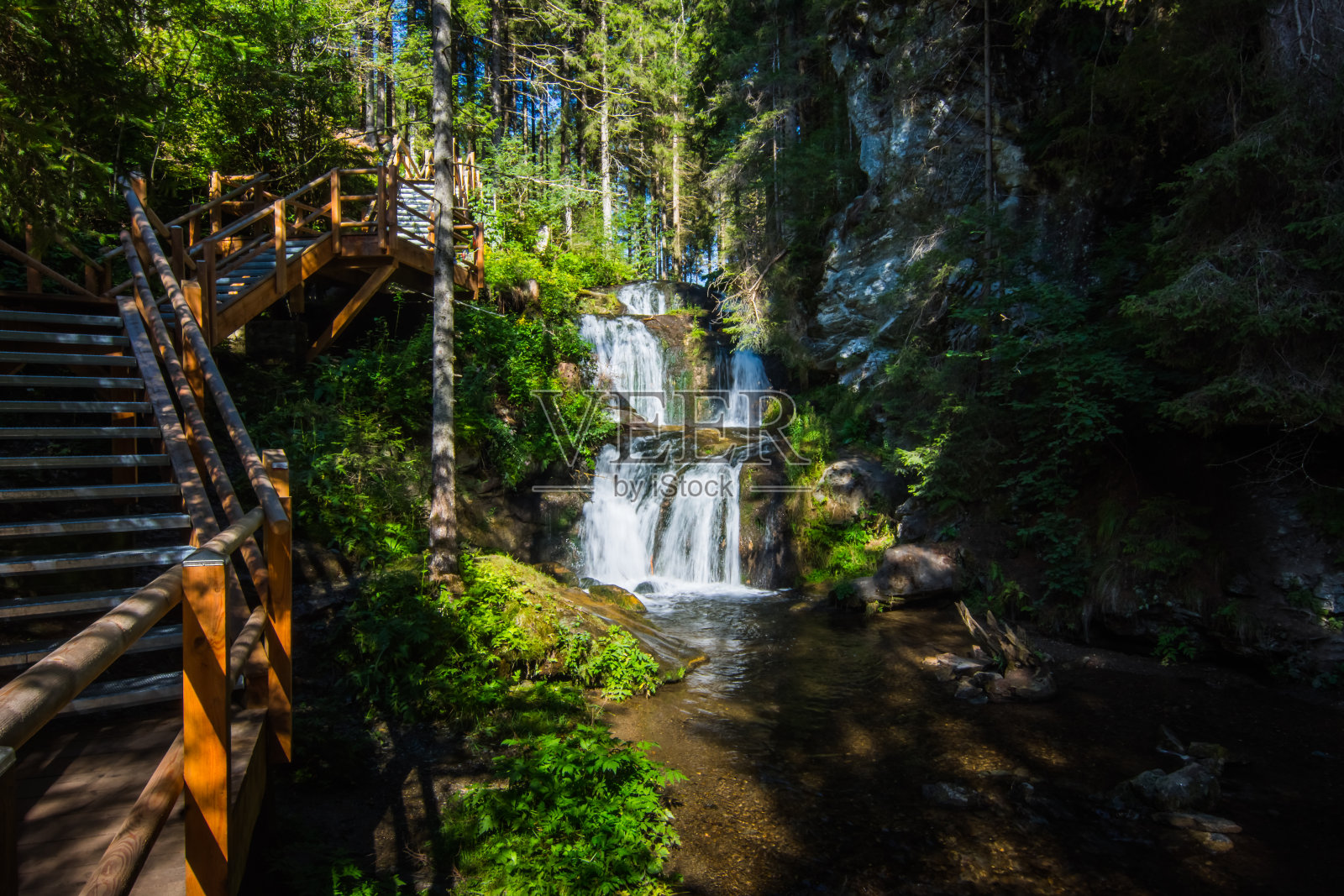 有木楼梯和小瀑布的黑暗峡谷照片摄影图片
