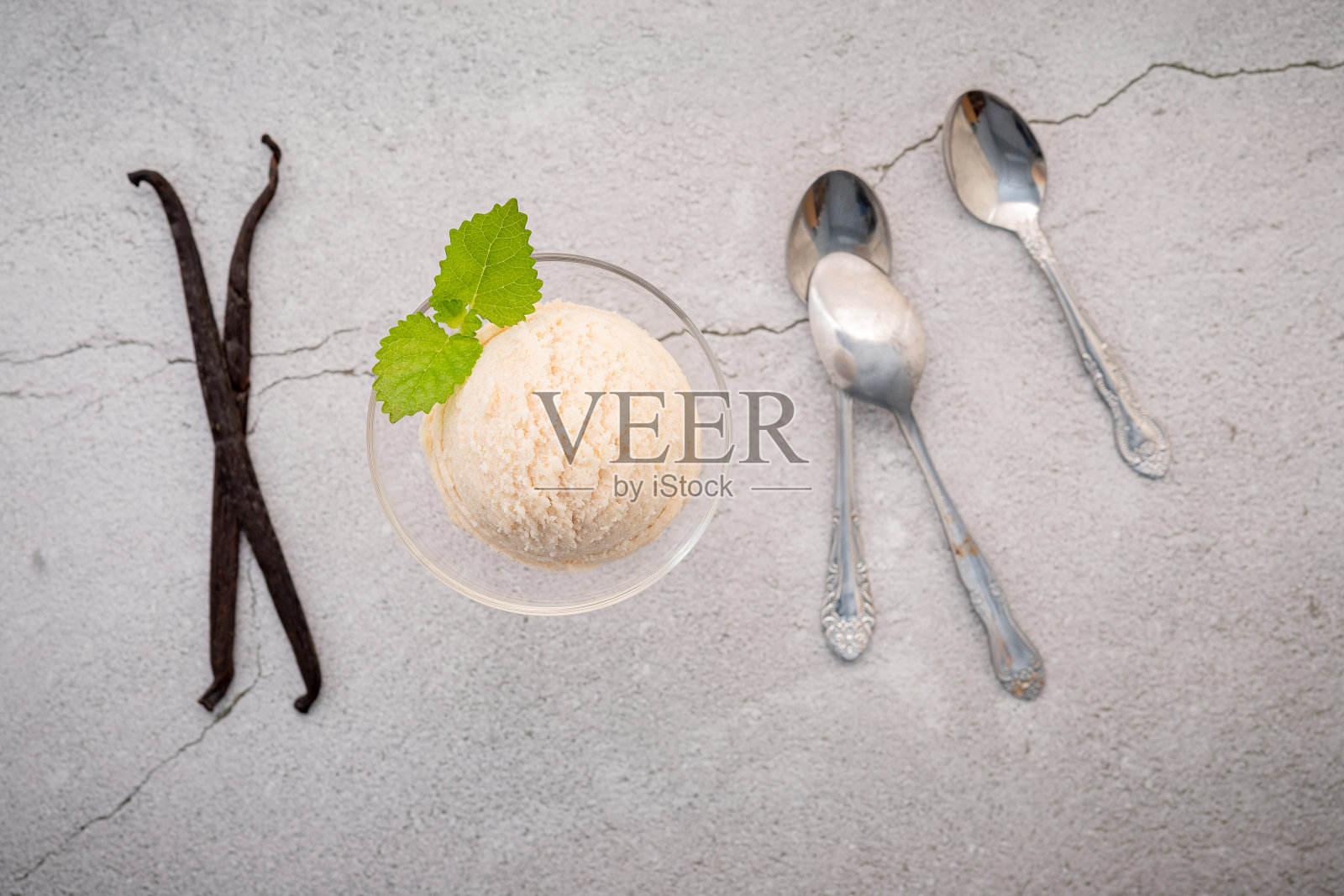 香草冰淇淋口味的碗与香草豆荚设置在混凝土背景。夏季和甜蜜的菜单概念。照片摄影图片