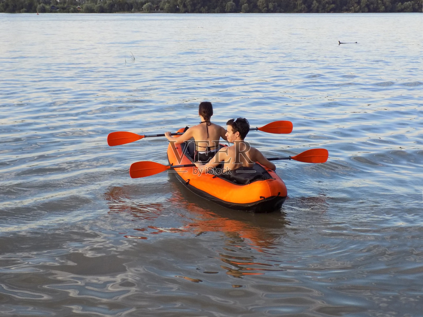 一对年轻夫妇在黄昏时分划皮划艇照片摄影图片
