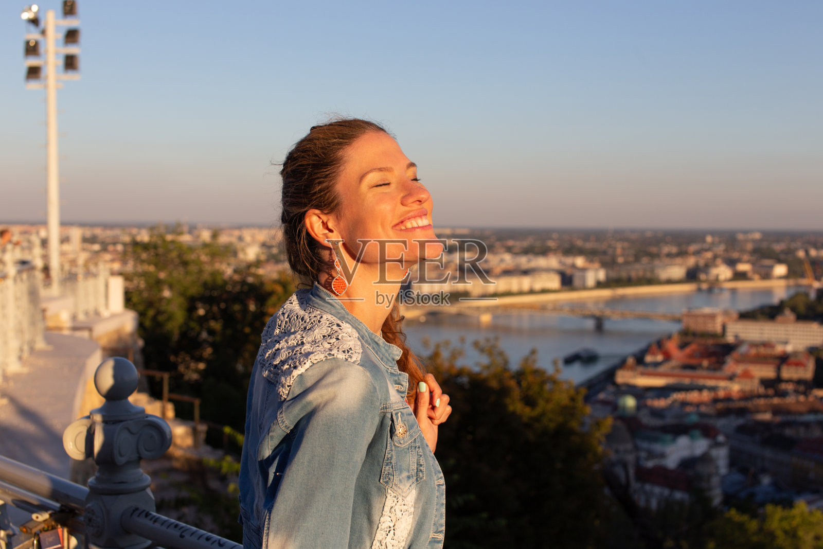 无忧无虑的年轻女子闭着眼睛欣赏日落照片摄影图片