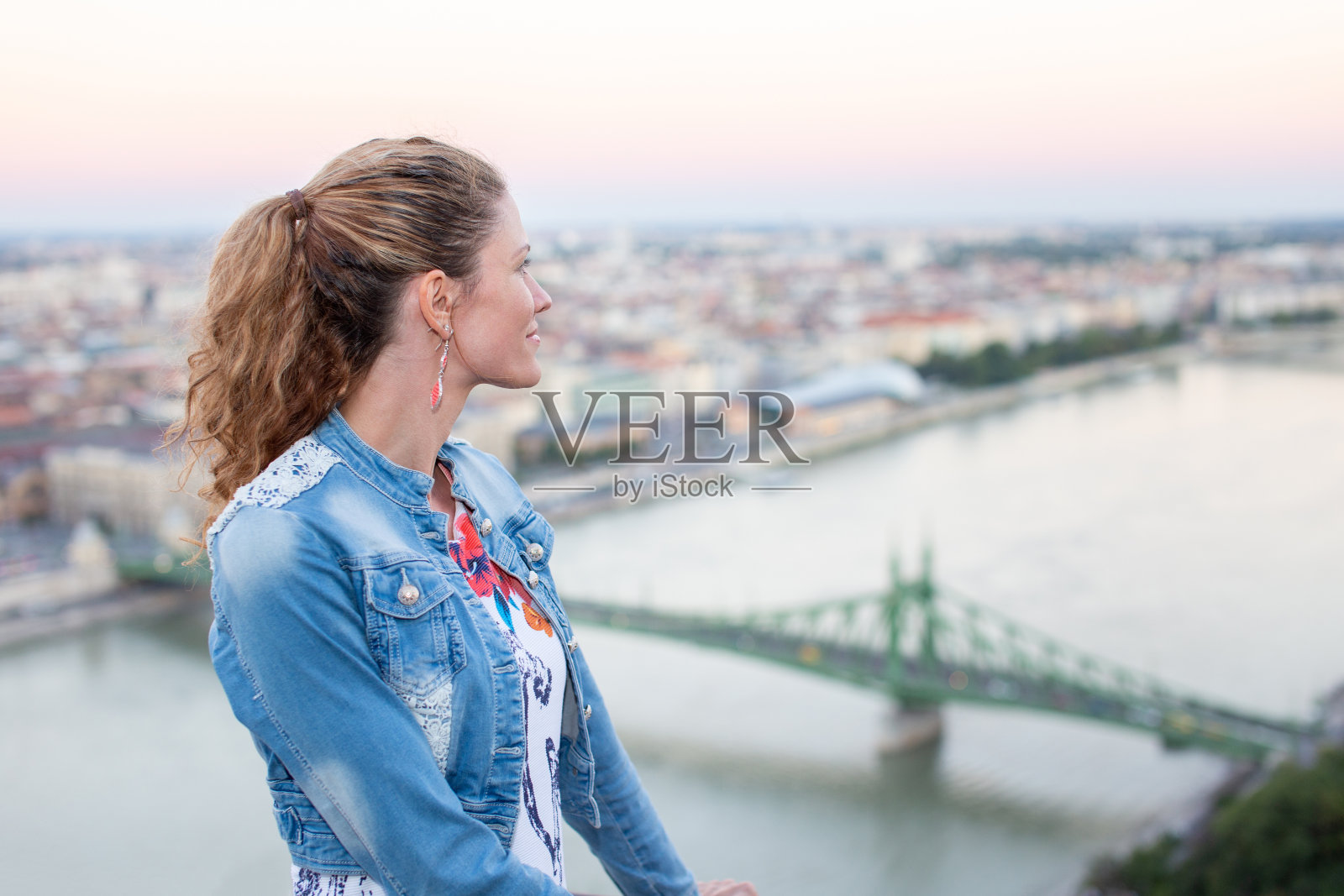 快乐的匈牙利白人妇女摆姿势在布达佩斯全景与牙齿微笑照片摄影图片