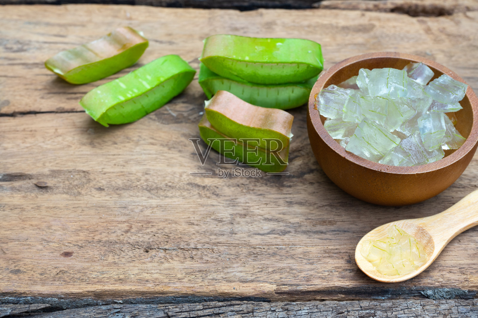 新鲜芦荟茎片和凝胶木桌，皮肤治疗概念，复制空间照片摄影图片