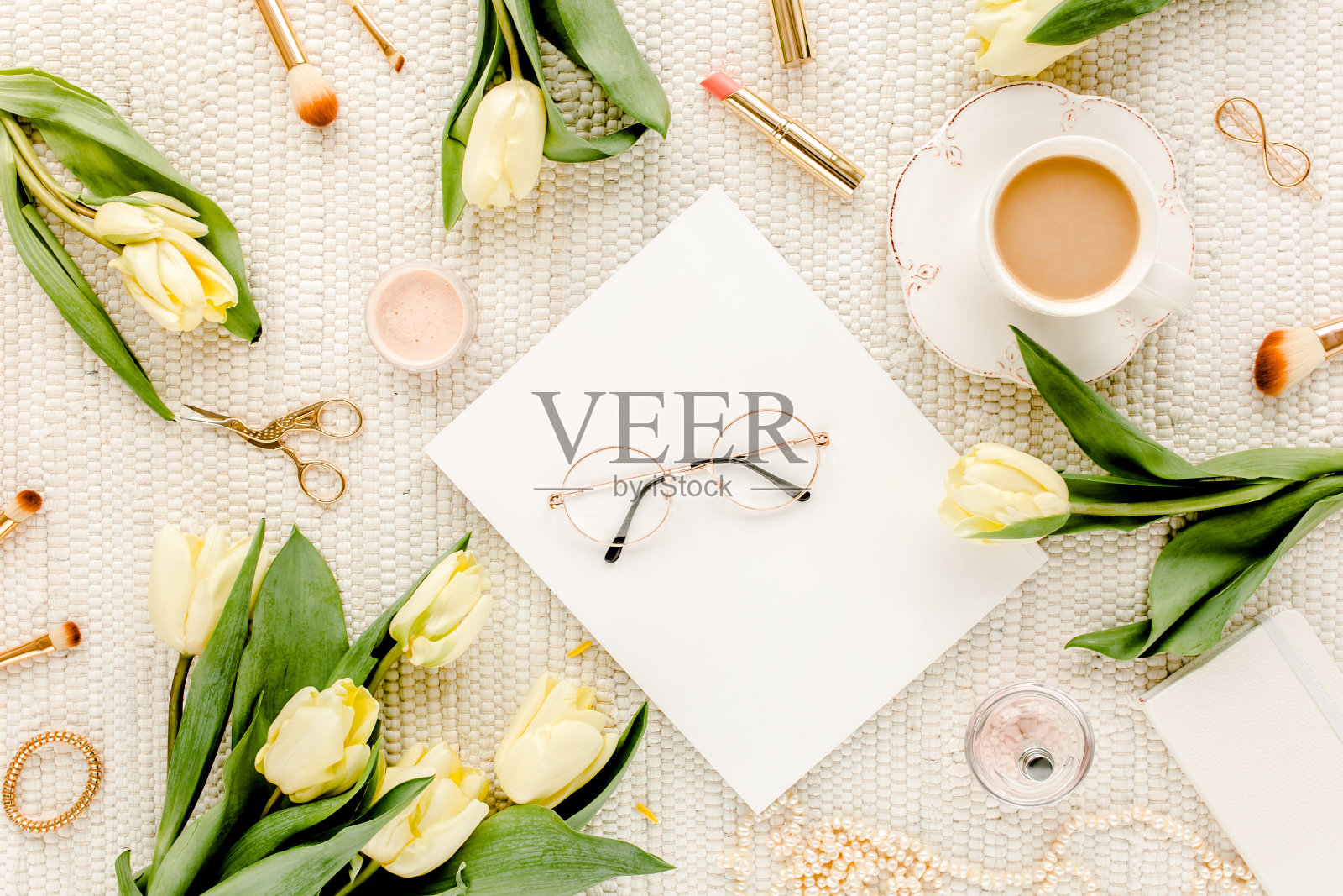 黄色的郁金香花，金色的女装配饰，日记本，白色背景的眼镜。平的。顶视图的女性照片摄影图片