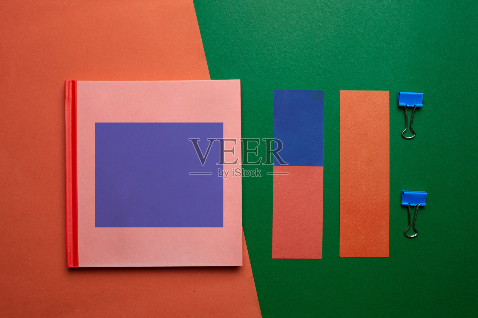 彩色的粉蓝色笔记本纸和回形针在复古风格的商业绿橙色背景照片摄影图片