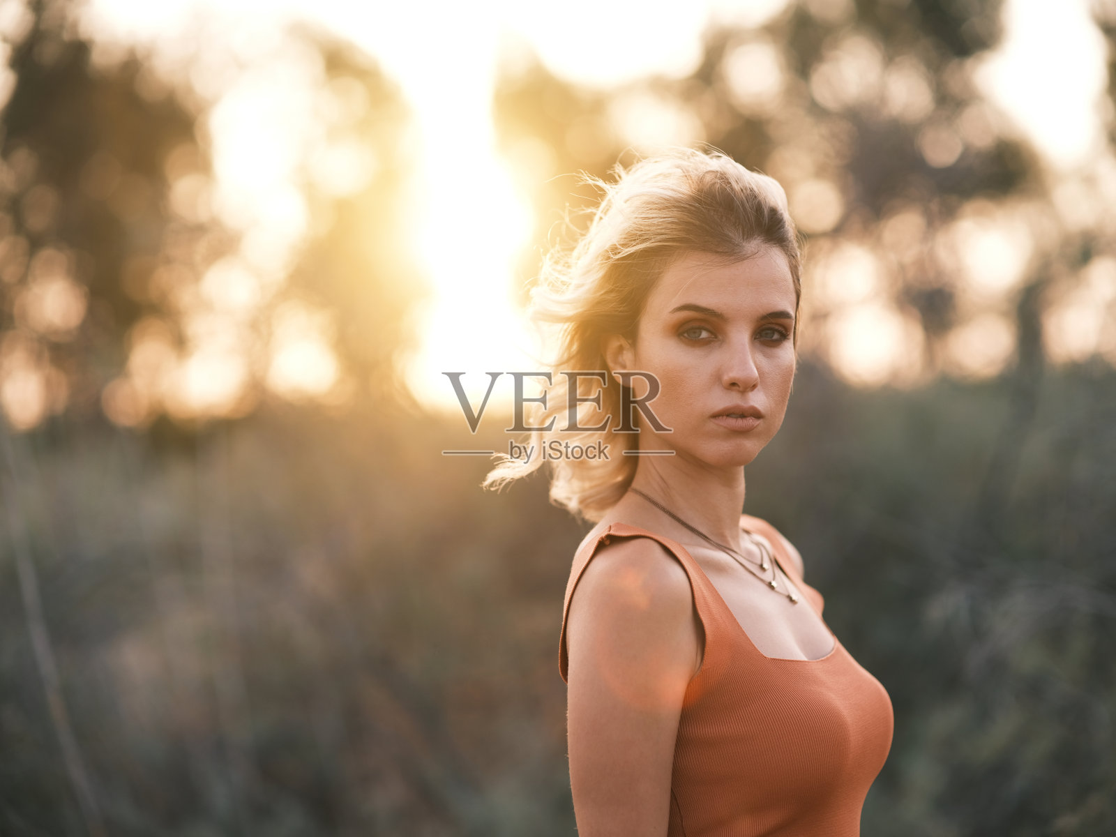 年轻女子的肖像在户外拥有阳光耀斑照片摄影图片