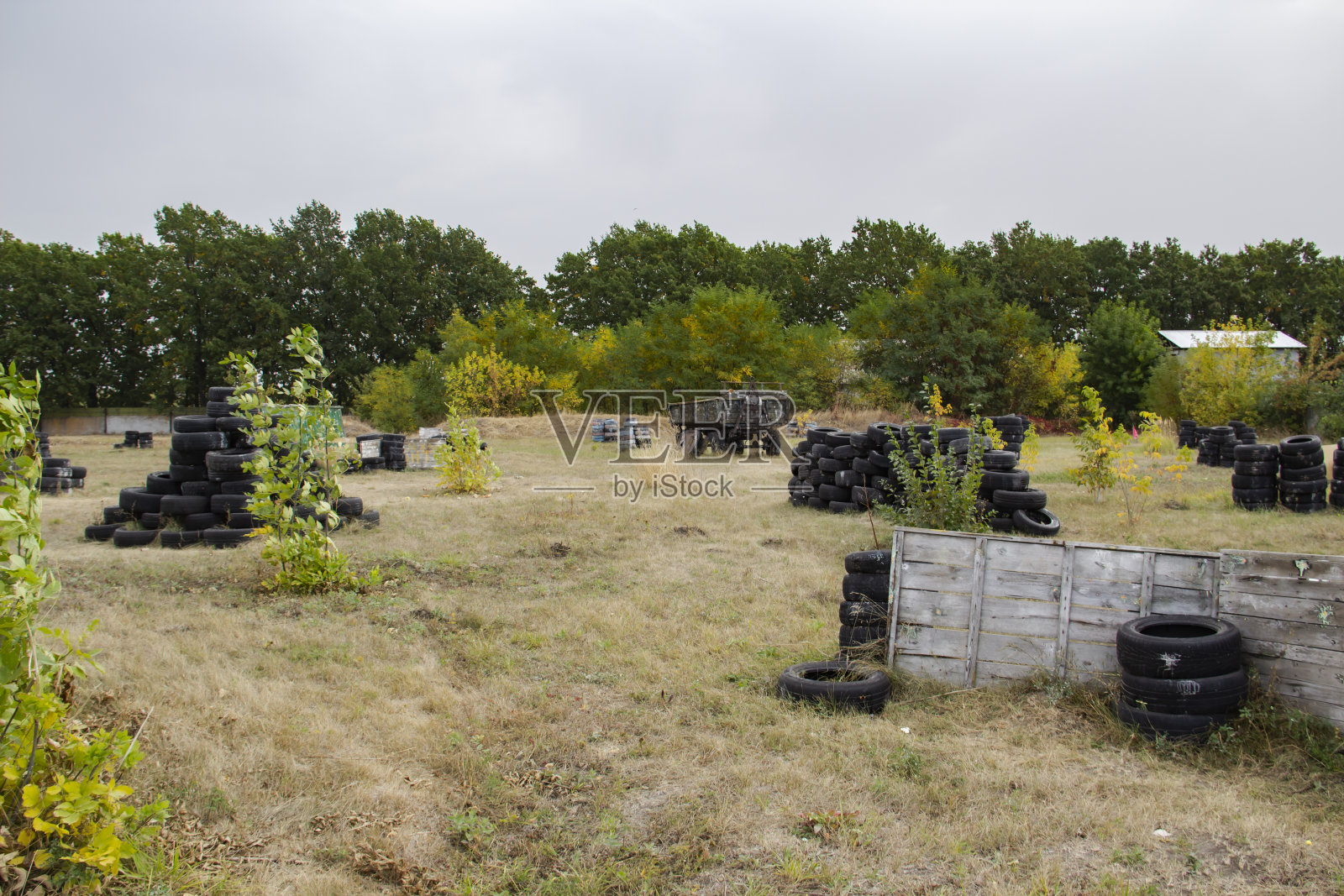 用打架后的油漆痕迹玩彩弹的空间。废弃的彩弹游乐场，路障是用旧轮胎和旧汽车零件做成的。照片摄影图片