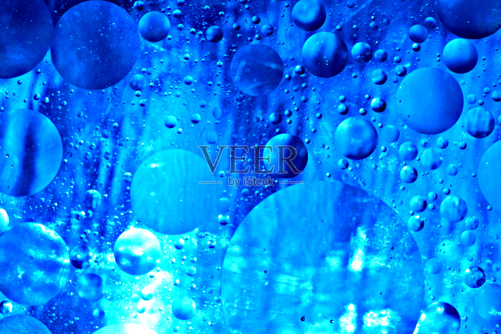 透明的气泡随机地分布在水面上。照片摄影图片