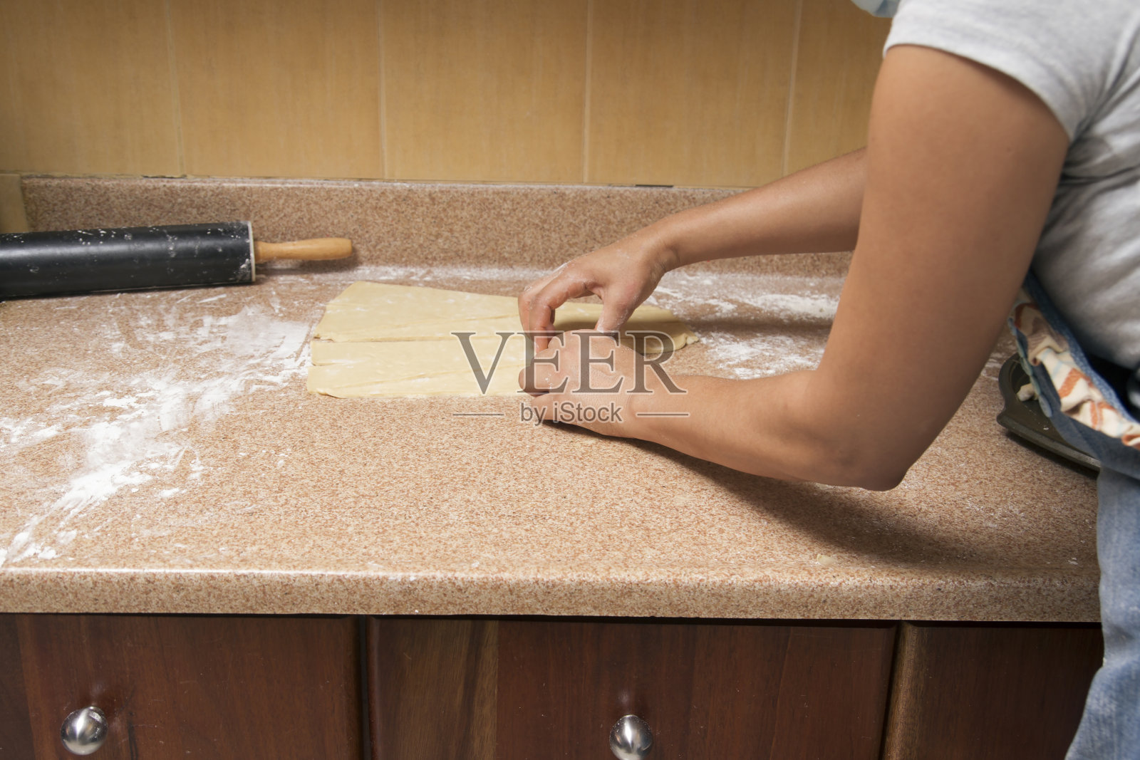 后视图的匿名妇女准备面团在花岗岩高原在厨房照片摄影图片