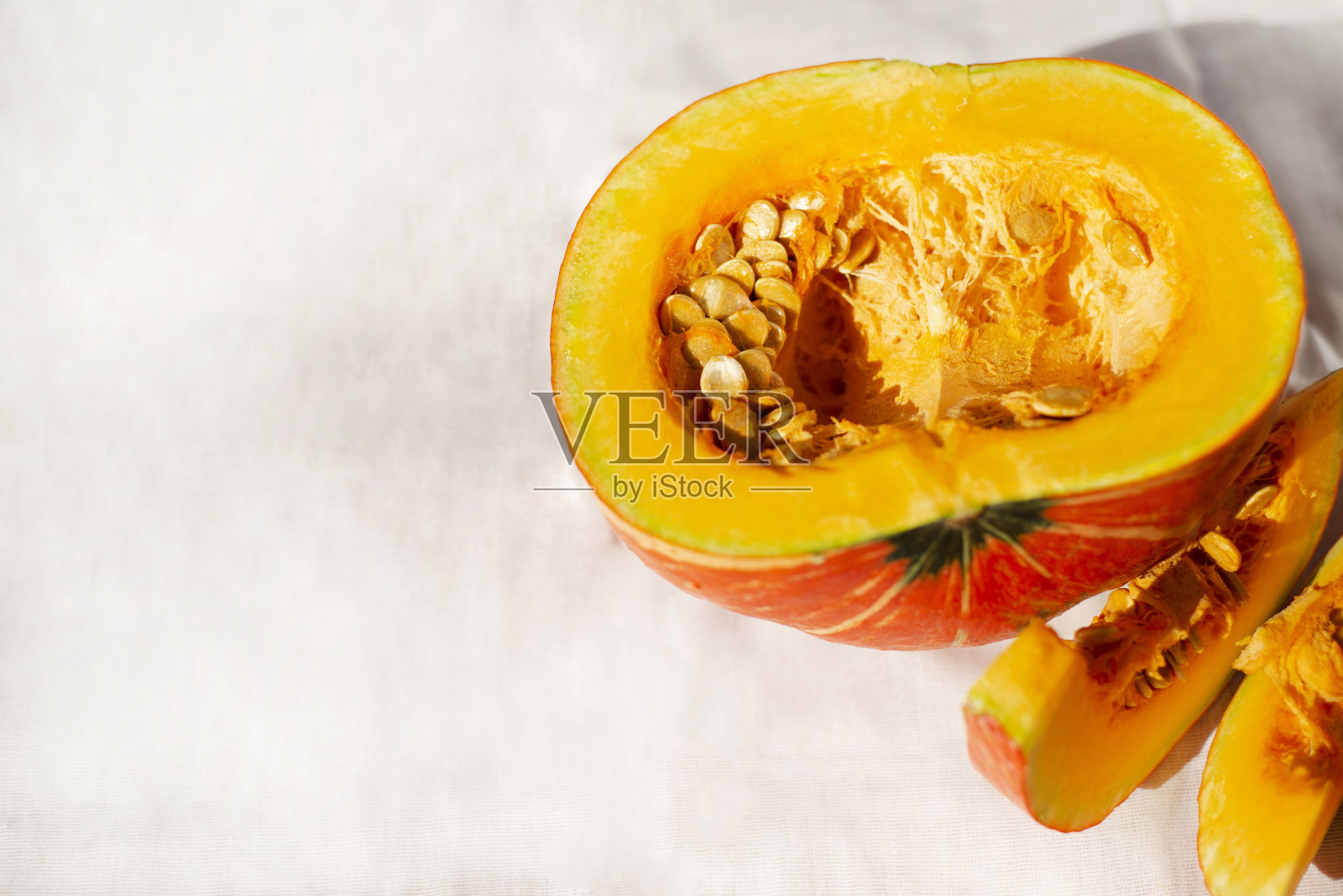 一半南瓜和白色餐巾上的切片。一个通用的消息公告模板，并设计了一个感恩节主题。照片摄影图片