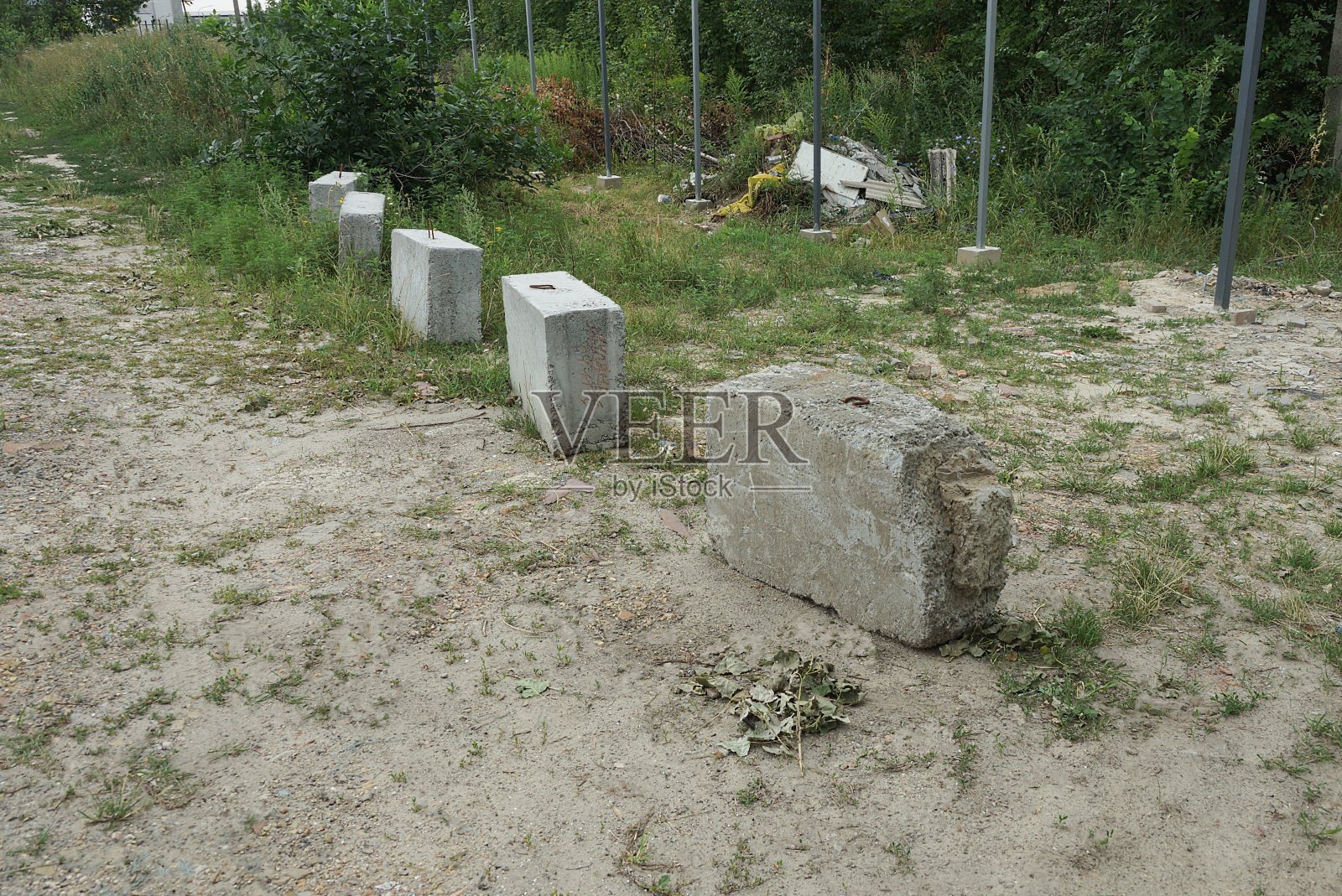 地上有一排灰色的混凝土砌块作为屏障照片摄影图片