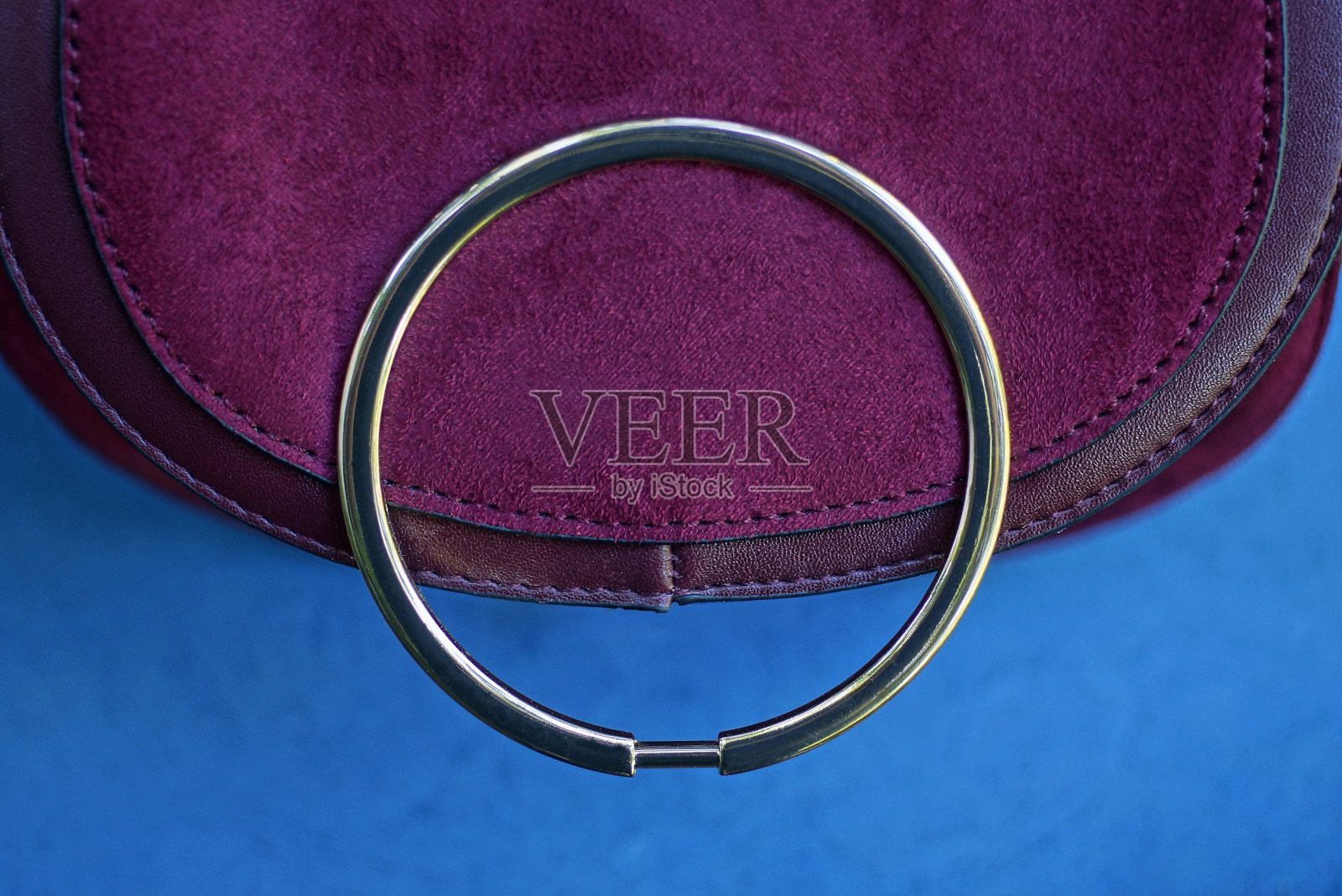 红色麂皮包与黄色圆形金属扣照片摄影图片