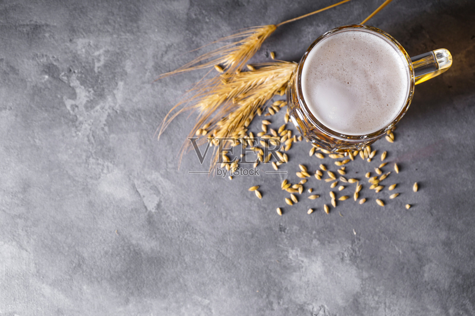 一杯淡啤酒和大麦在一个灰色的背景，平坦的lay和空间的文字照片摄影图片