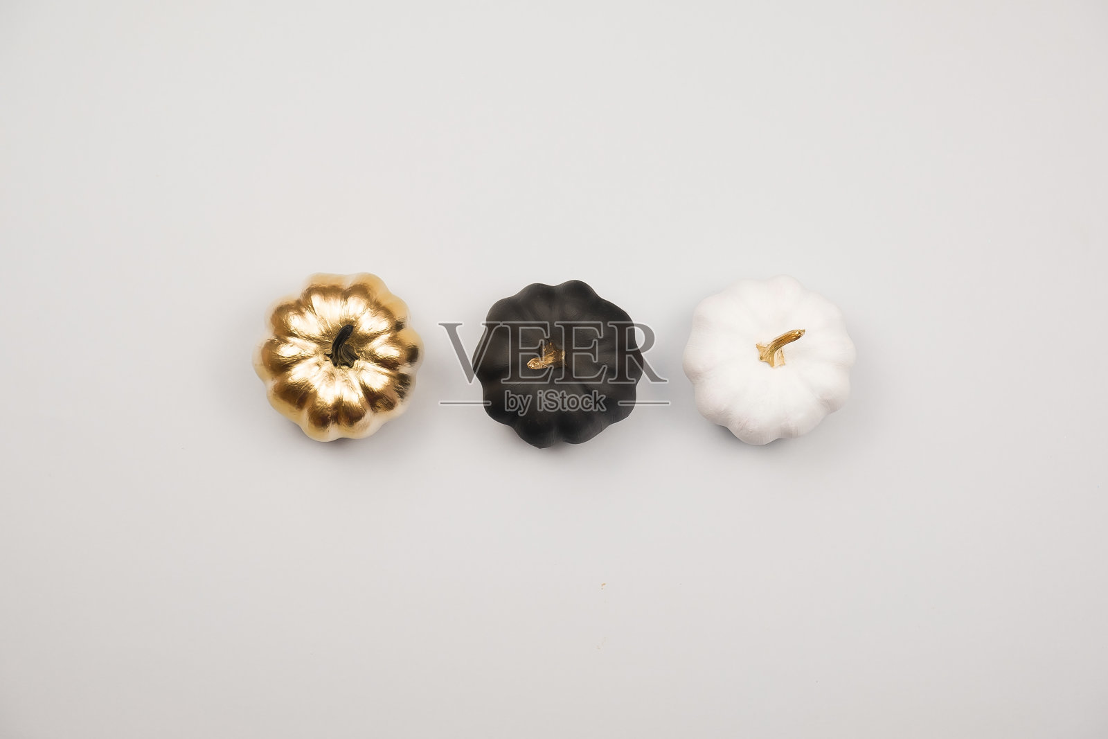 简约的万圣节节日概念。万圣节的装饰，金色，黑色和白色的南瓜。平铺，俯视图，拷贝空间照片摄影图片