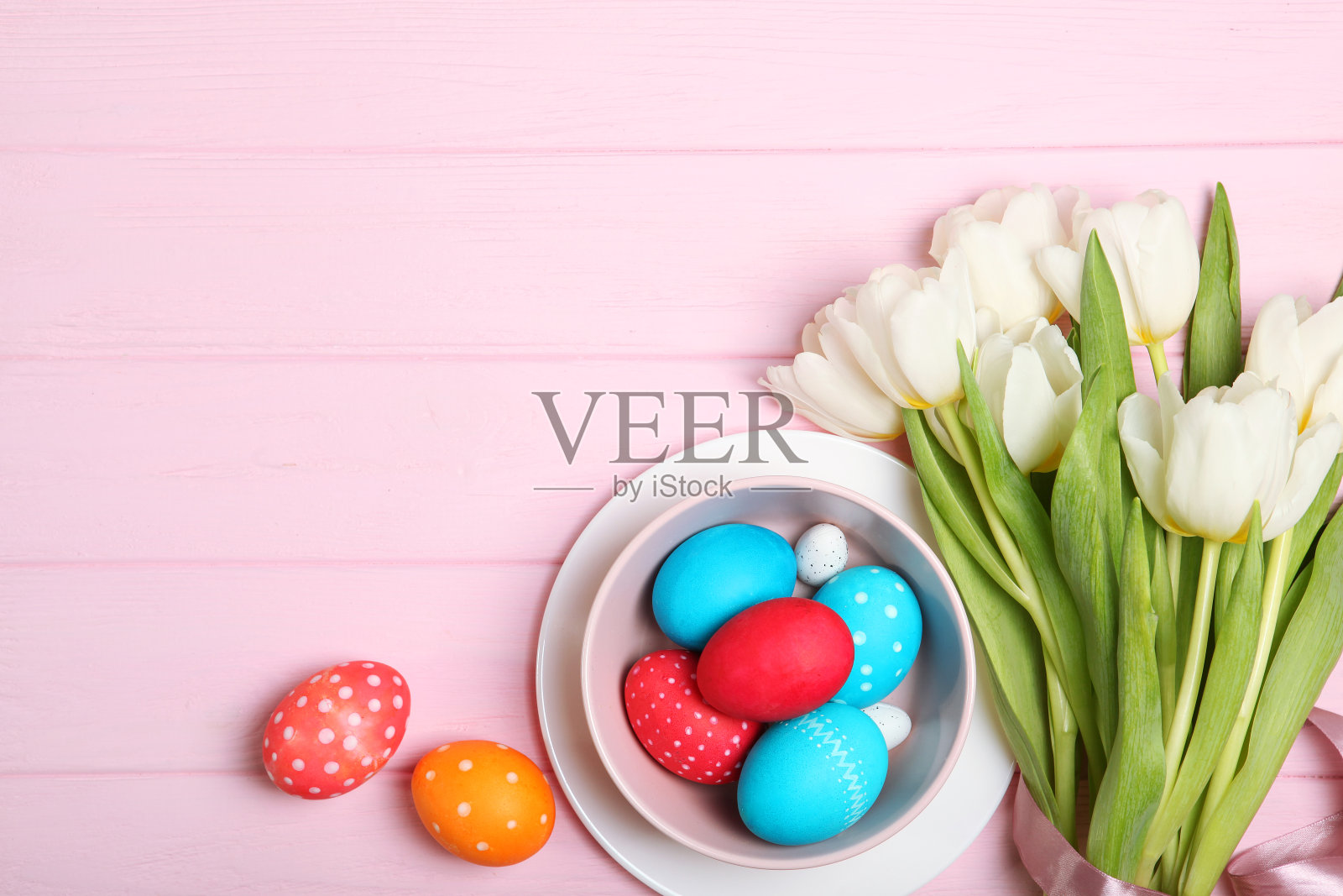 把复活节彩蛋和鲜花放在桌面上查看。复活节作文有插入文字的地方。照片摄影图片