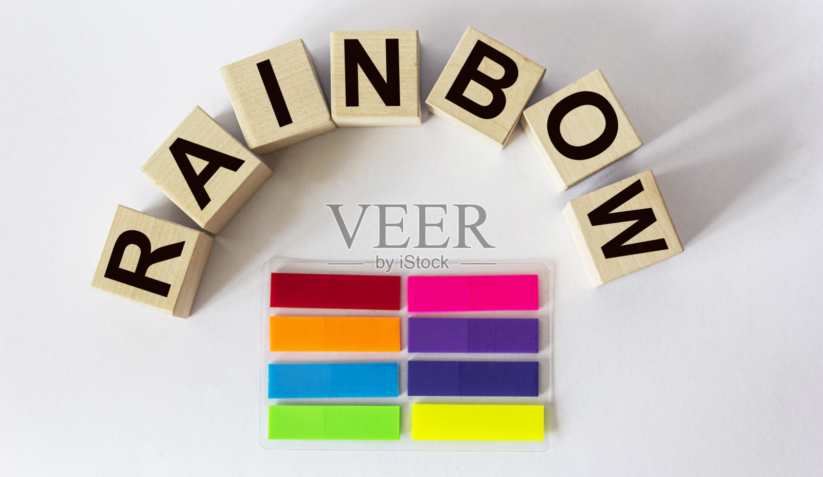 彩虹，在彩色贴纸的背景上用木块做的字照片摄影图片