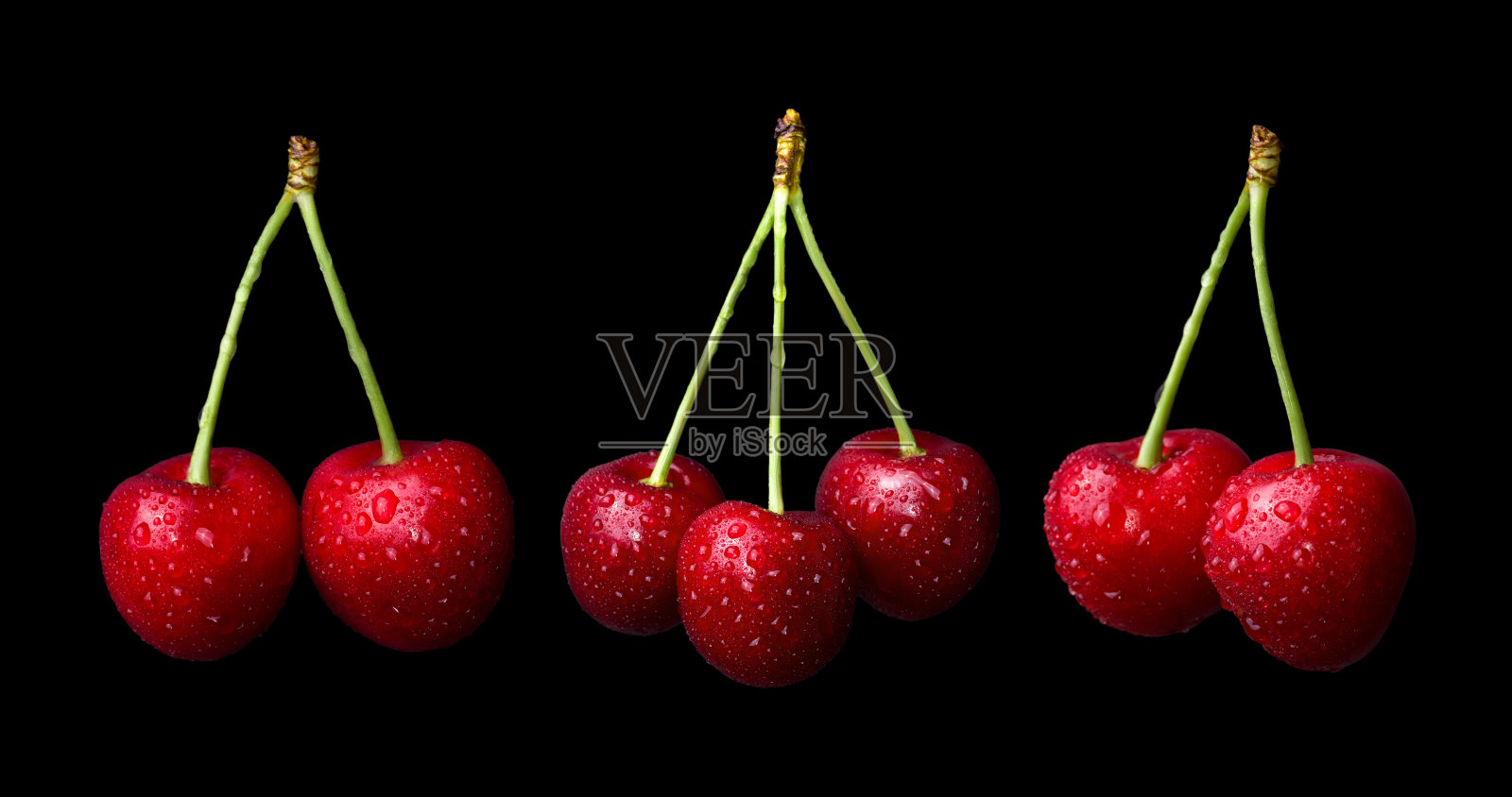 一套新鲜成熟的樱桃与水珠孤立在黑色的背景。照片摄影图片