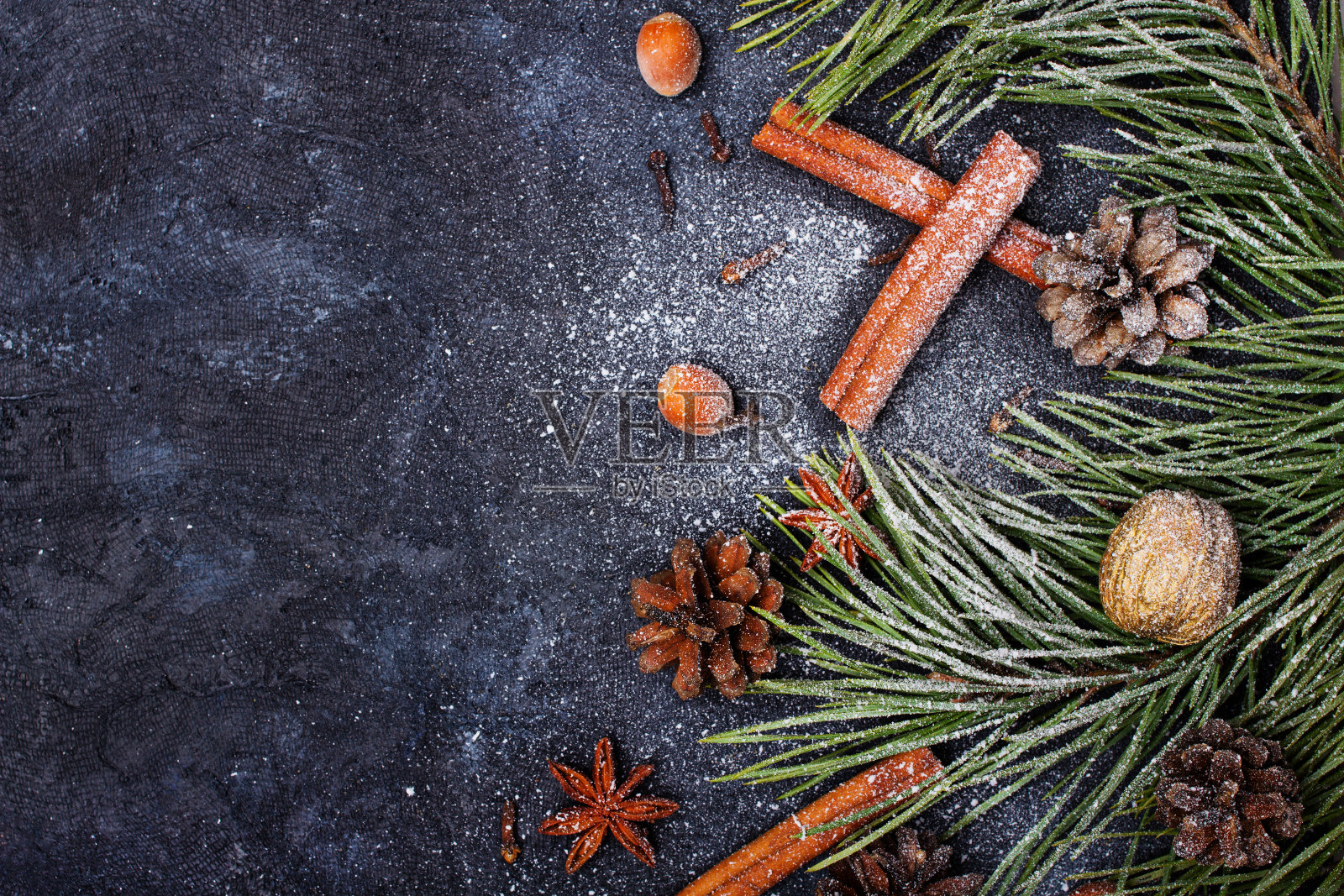 美丽的圣诞背景与复制空间为您的文本。松枝，松果，肉桂，覆盖着雪的坚果照片摄影图片