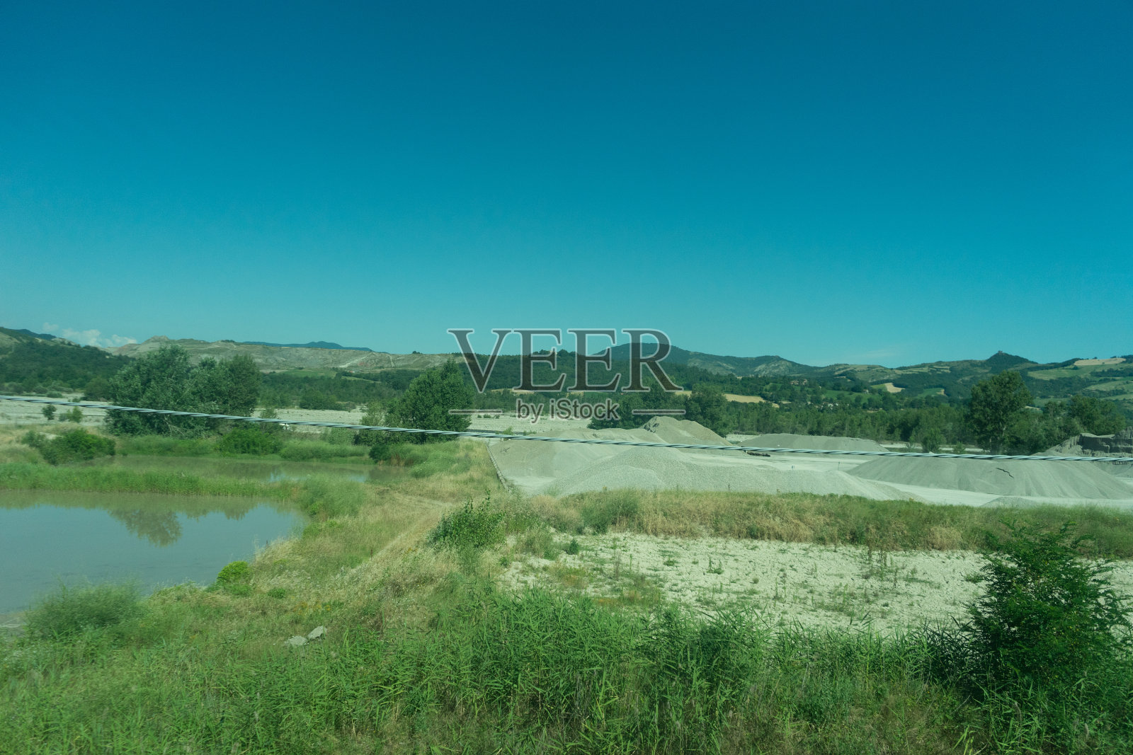 意大利，从拉斯佩齐亚到卡斯特鲁斯的火车，一条流经草地的河流照片摄影图片