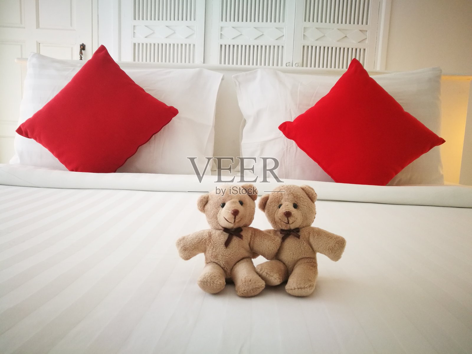 卧室里面的床上躺着一对可爱的夫妇，舒适的白色大床。mordrn室内设计。照片摄影图片