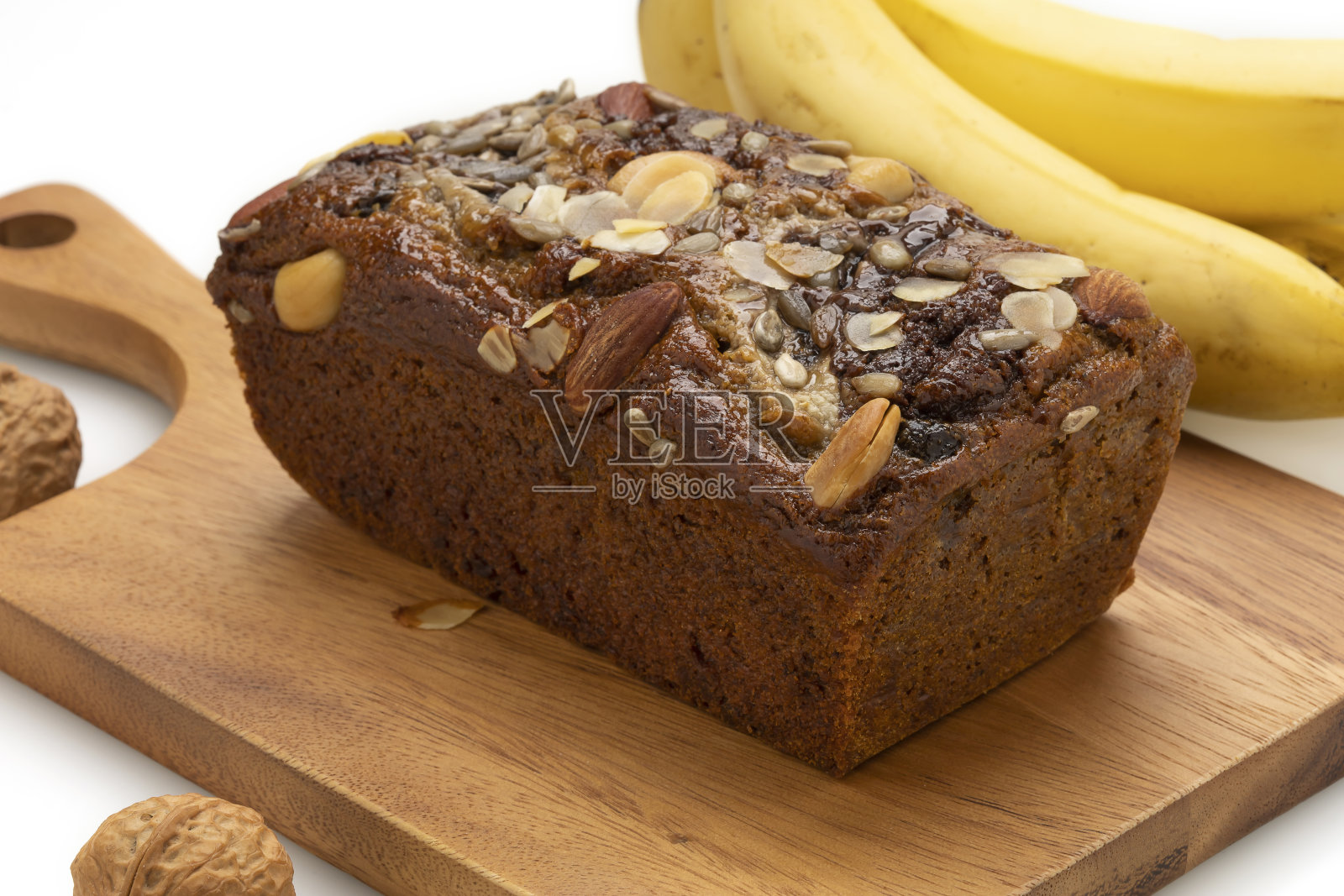 特写香蕉面包在木盘子上，香蕉孤立在白色的背景。照片摄影图片