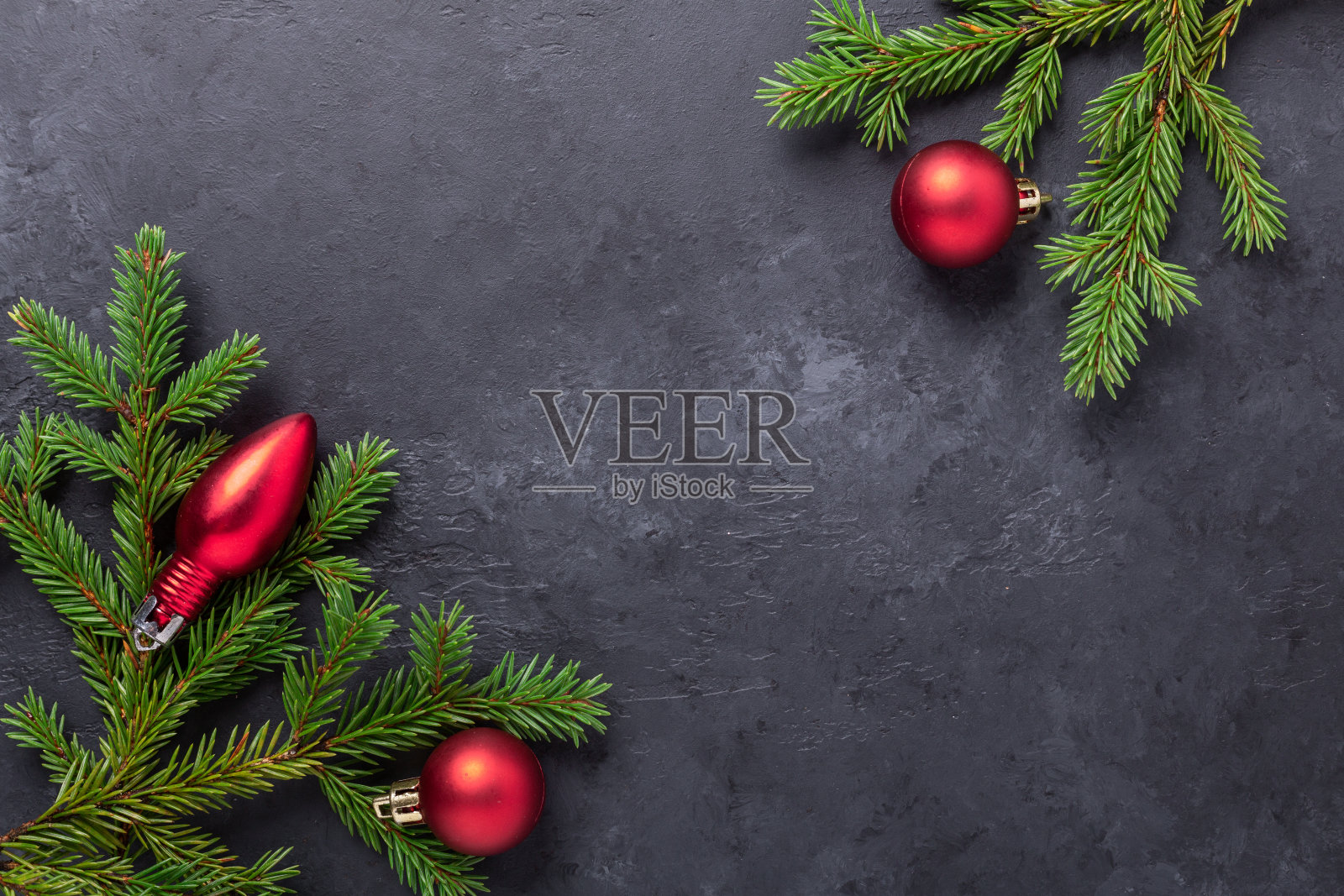 圣诞背景与冷杉树和红色的球在黑色的石头桌上。拷贝空间照片摄影图片