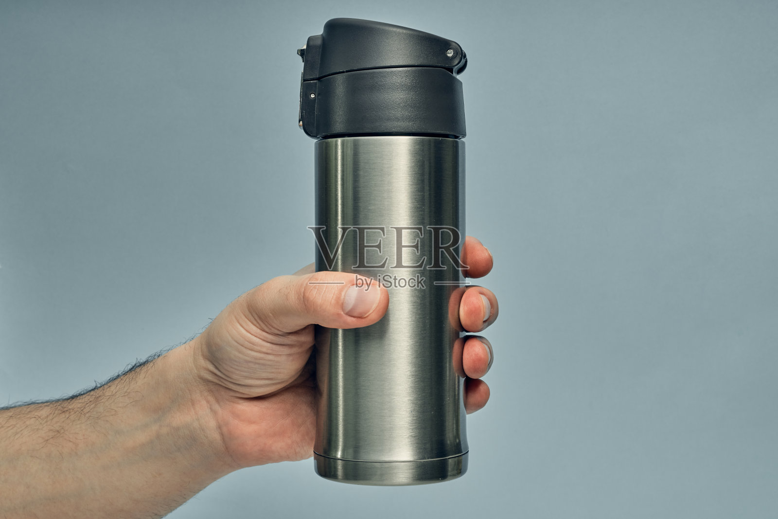 金属杯保温杯在彩色背景上。边走边喝热饮。热杯子。照片摄影图片