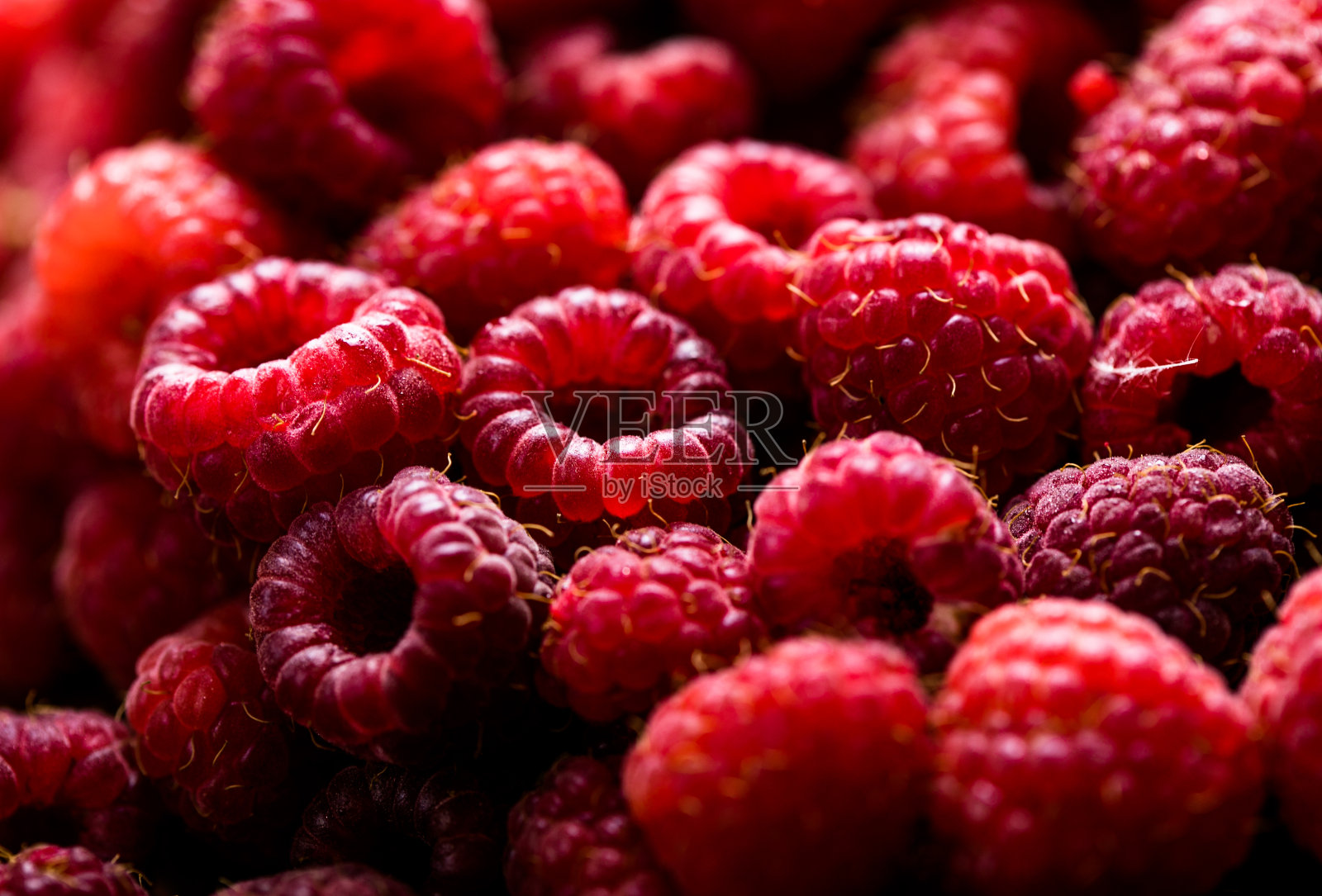 新鲜甜美的红覆盆子口感。水果堆背景照片摄影图片