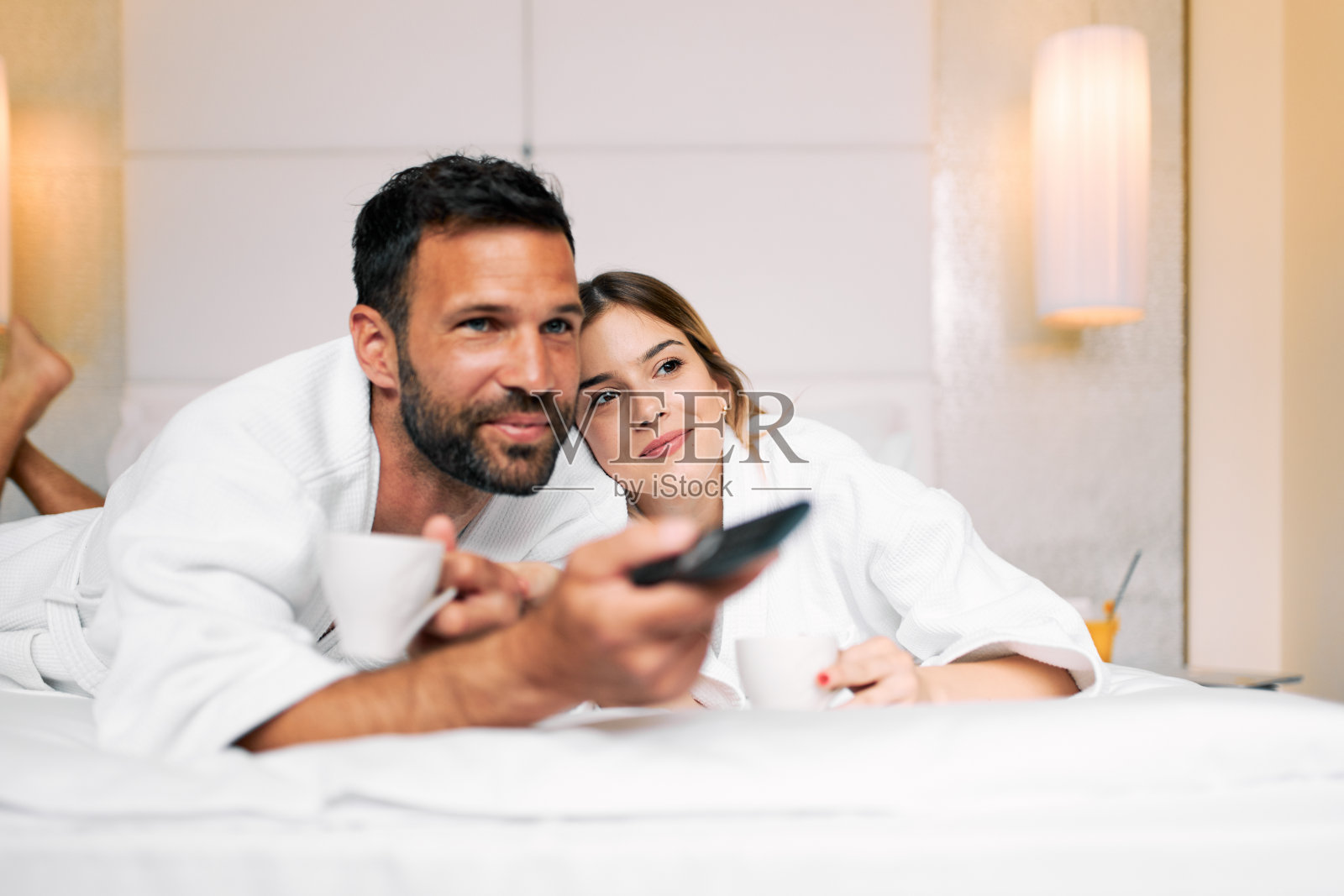 一对夫妇在酒店房间里看电视照片摄影图片