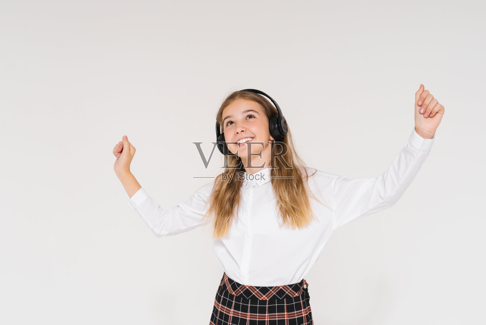 快乐的少女与长头发校服耳机隔离在白色的背景照片摄影图片