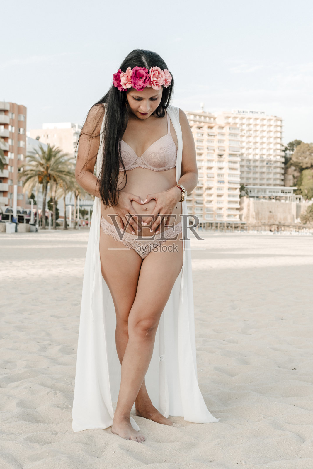 怀孕的母亲在马略卡海滩的沙滩上照片摄影图片