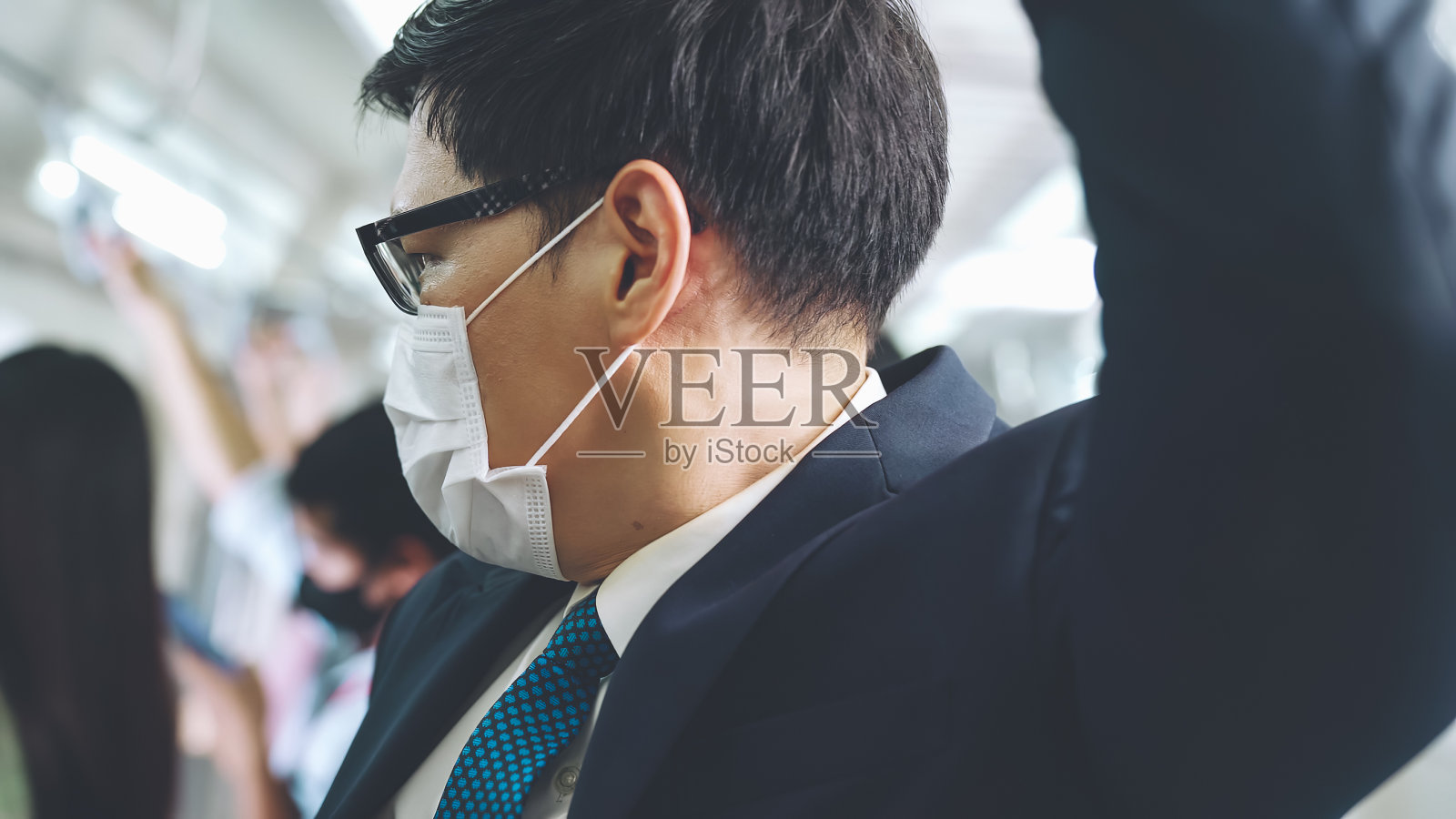 戴口罩的年轻人乘坐拥挤的地铁照片摄影图片