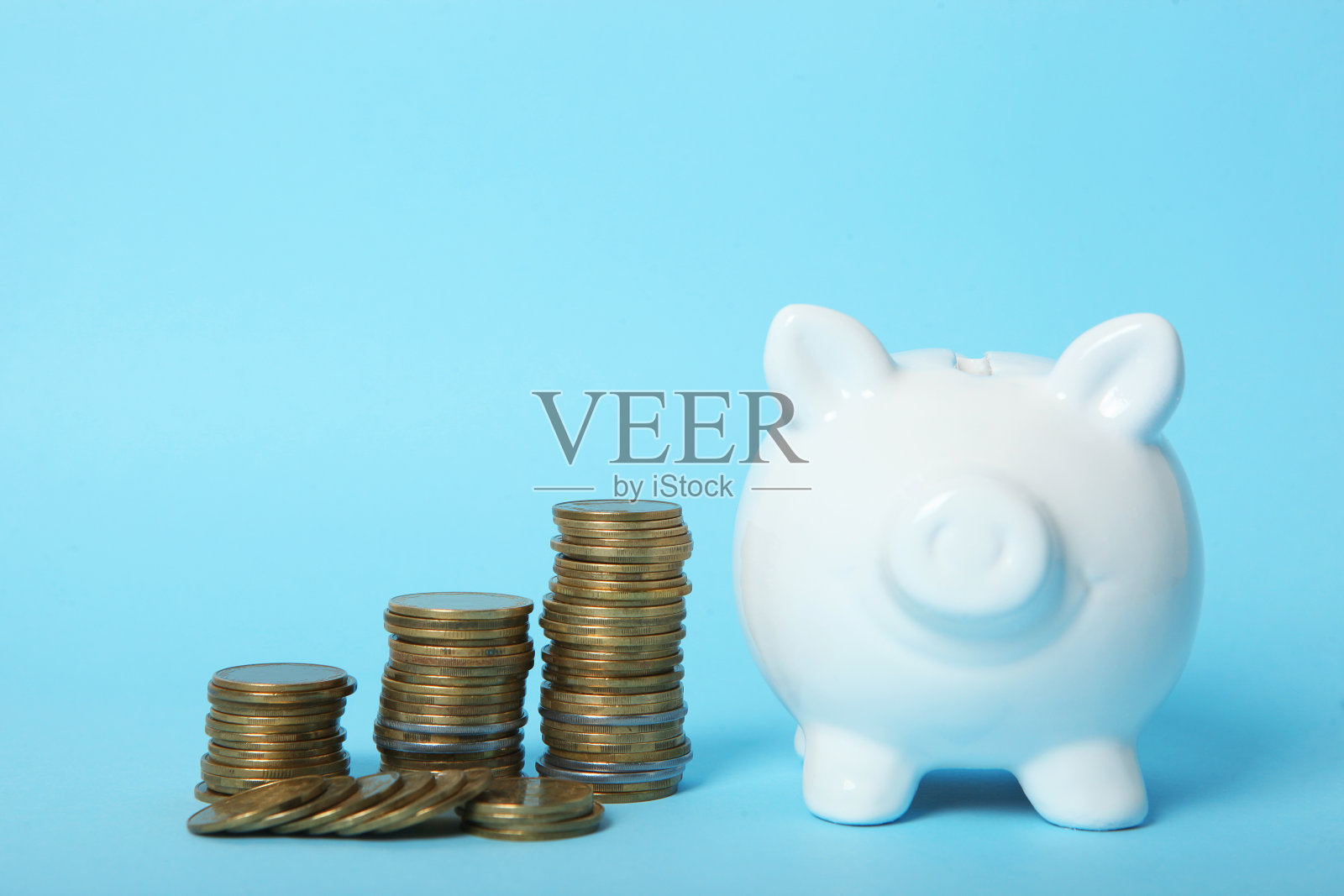 小猪储蓄罐上的彩色背景。存钱的概念。照片摄影图片