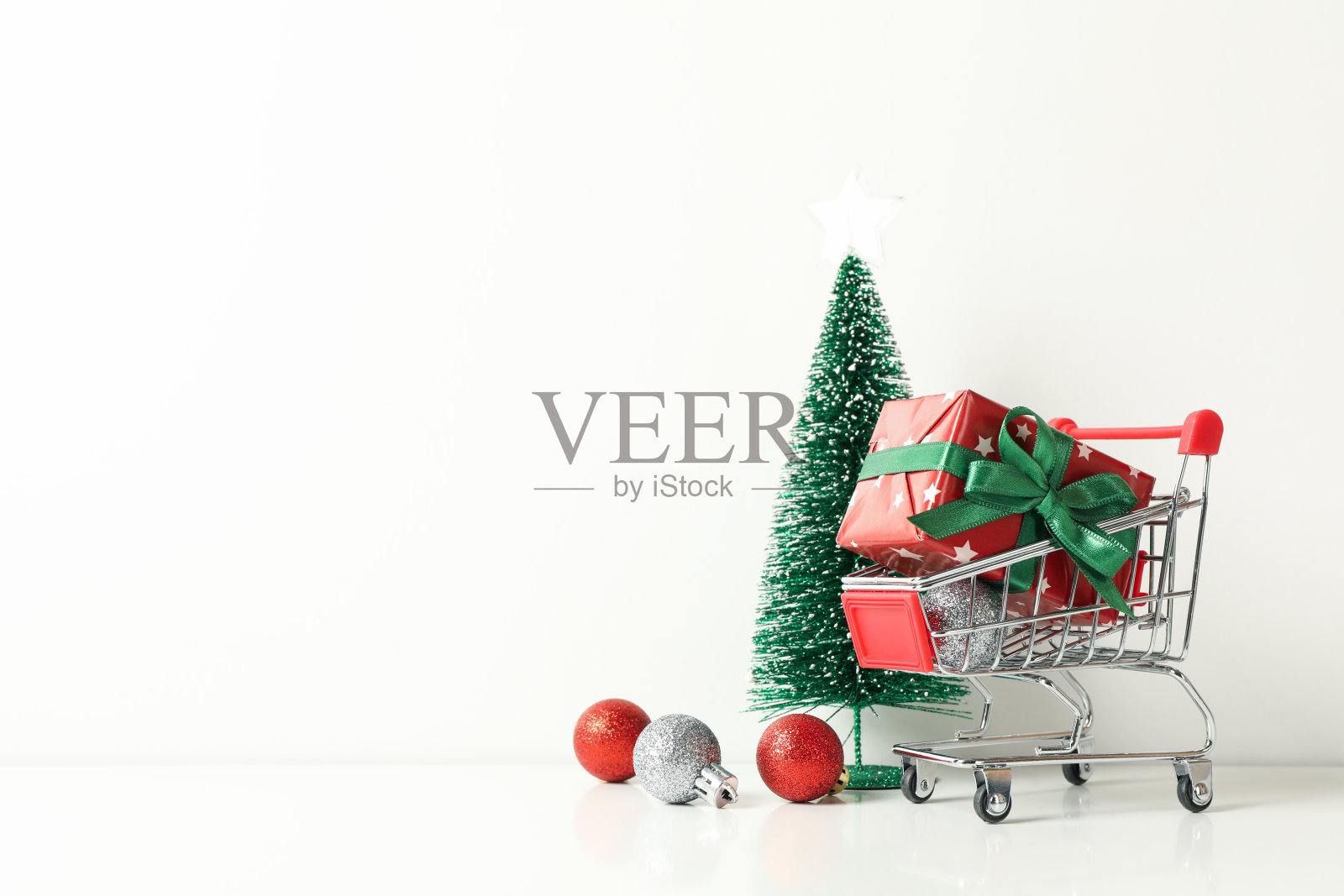 购物车与礼物盒和圣诞配件在白色的背景照片摄影图片