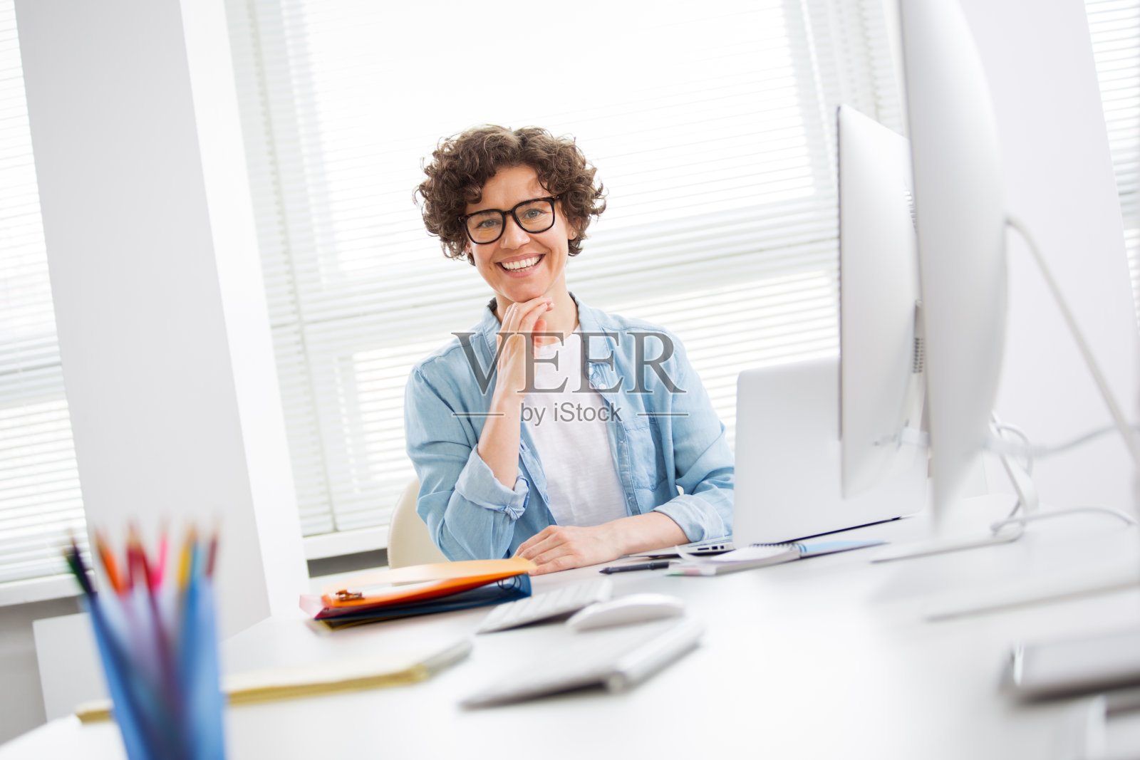 商业女性在办公室里看着照相机的肖像照片摄影图片