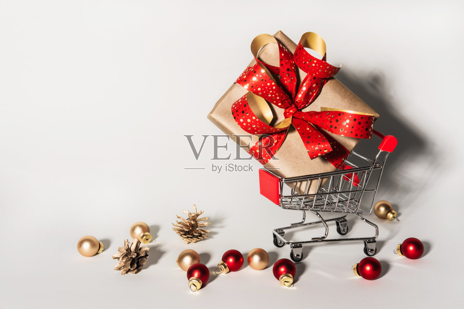 购物车里有礼物盒和圣诞玩具球。圣诞购物礼物概念照片摄影图片