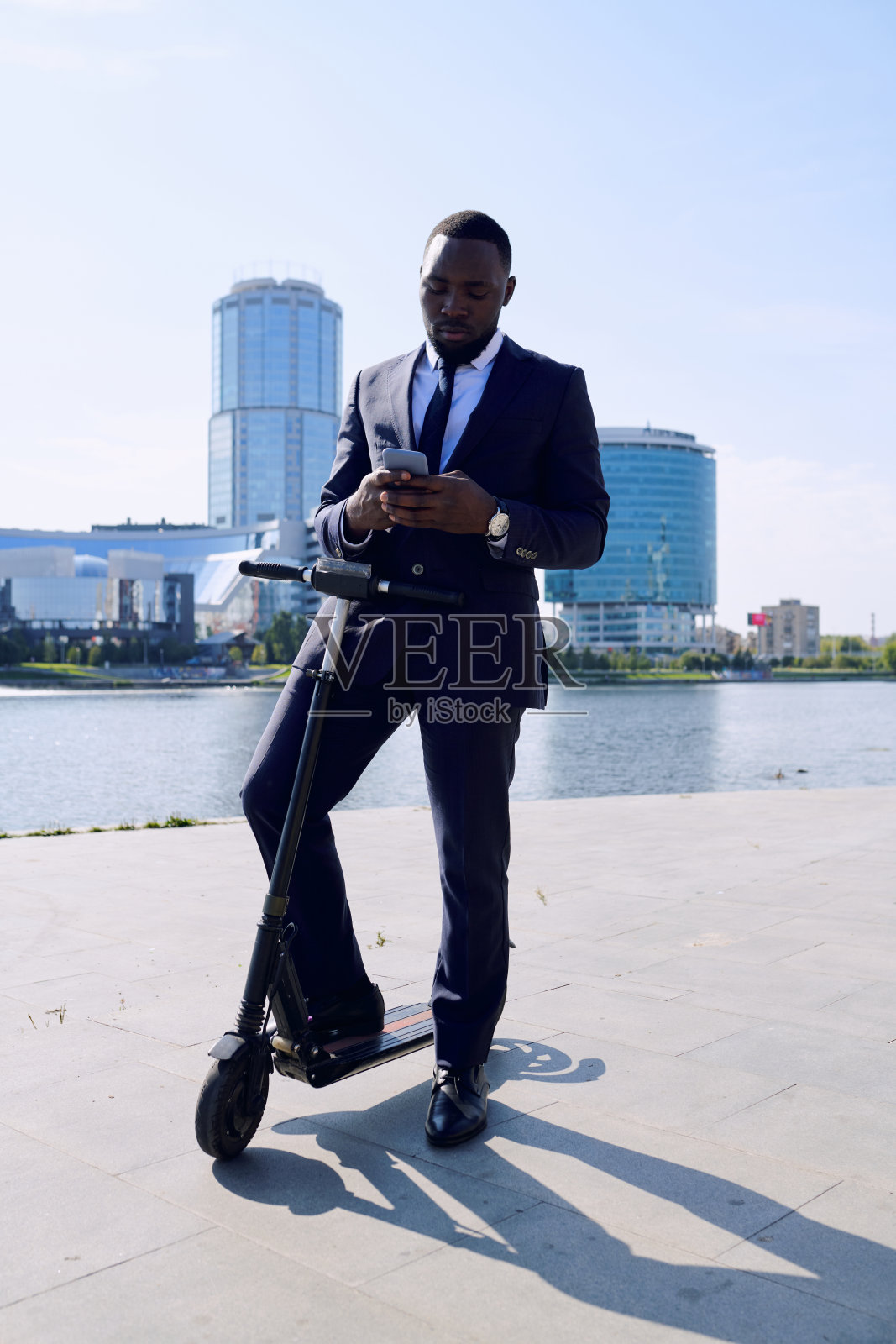 年轻优雅的非洲裔商人站在电动车上照片摄影图片