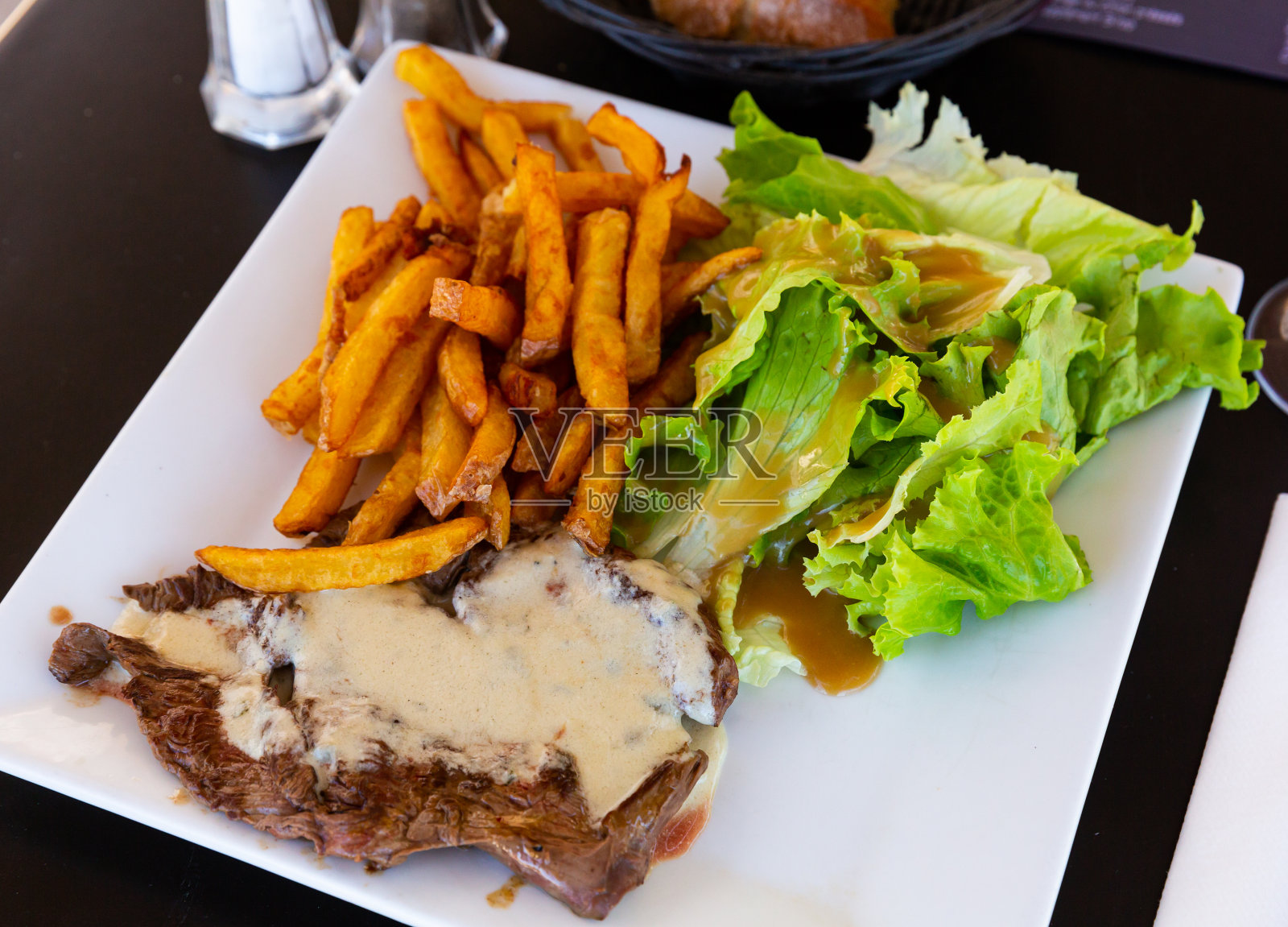 牛扒配羊乳干酪沙司配烤土豆照片摄影图片