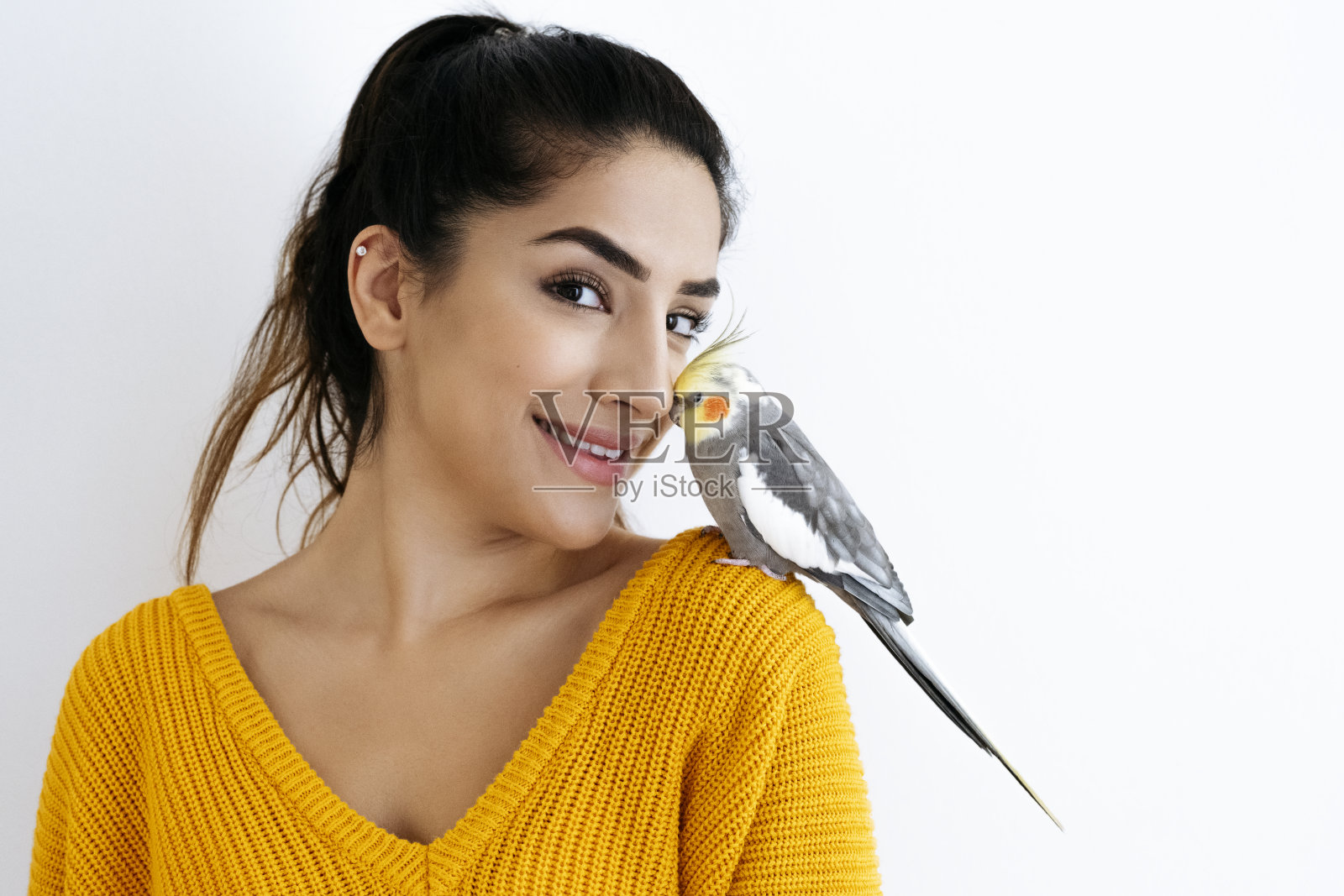 一个年轻的印度女人的肖像与宠物鹦鹉的鼻子照片摄影图片
