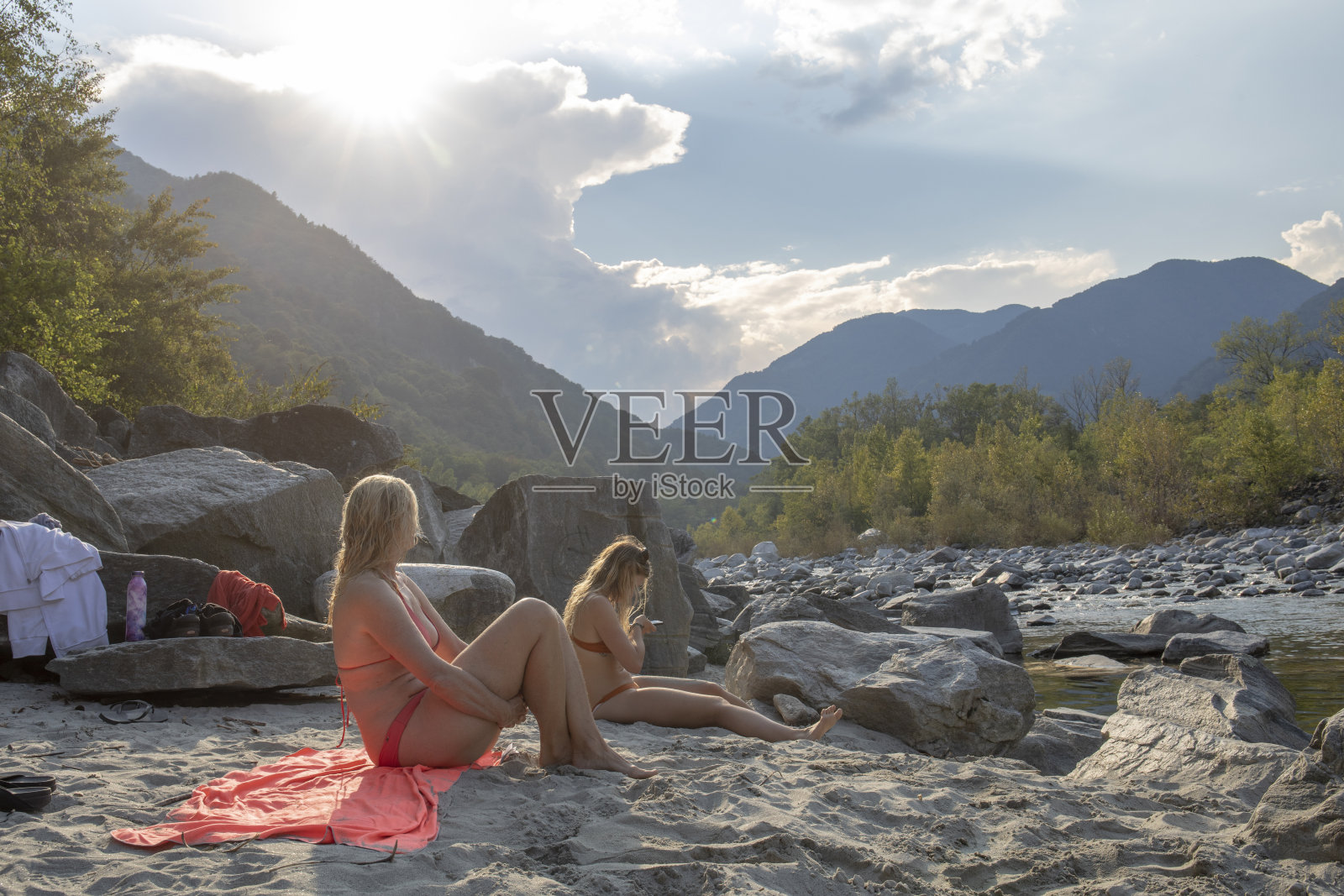 母女俩在湖岸沙滩上休息照片摄影图片