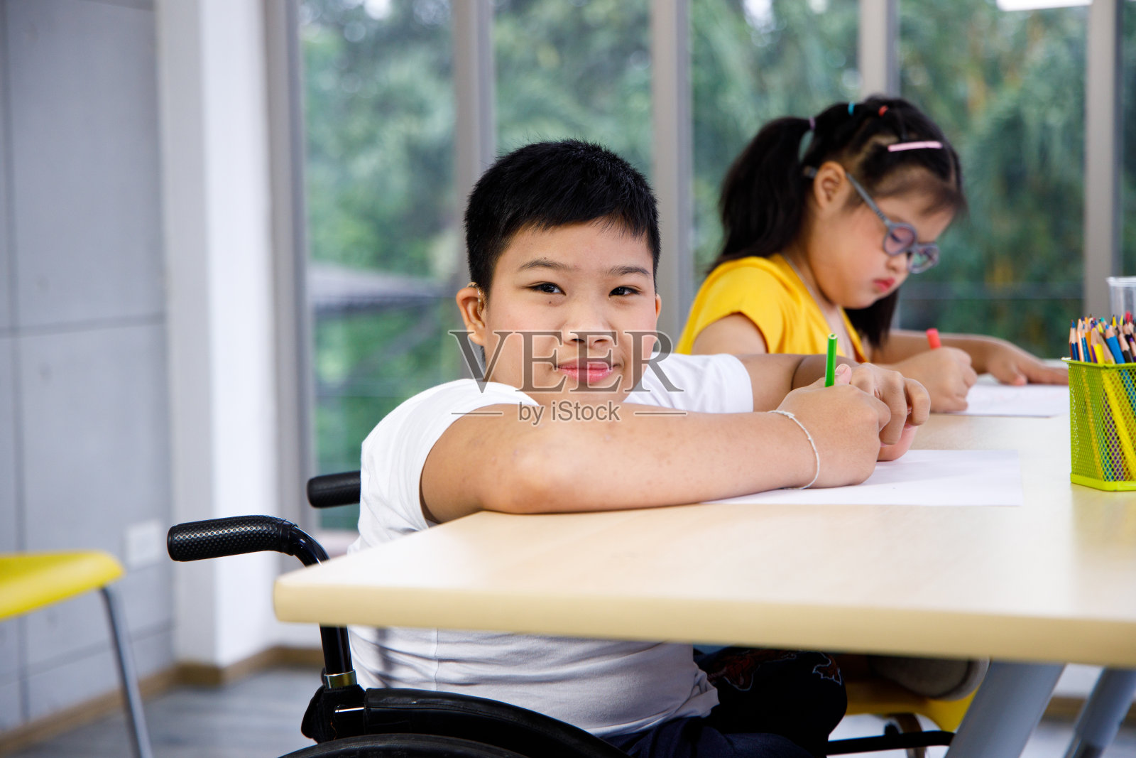 在学校学习的残疾男孩。照片摄影图片