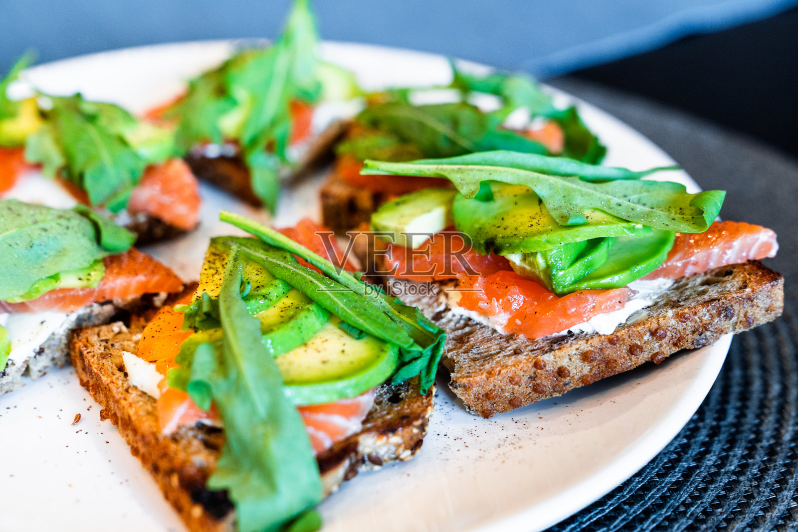 白盘子里有三文鱼和鳄梨三明治。照片摄影图片