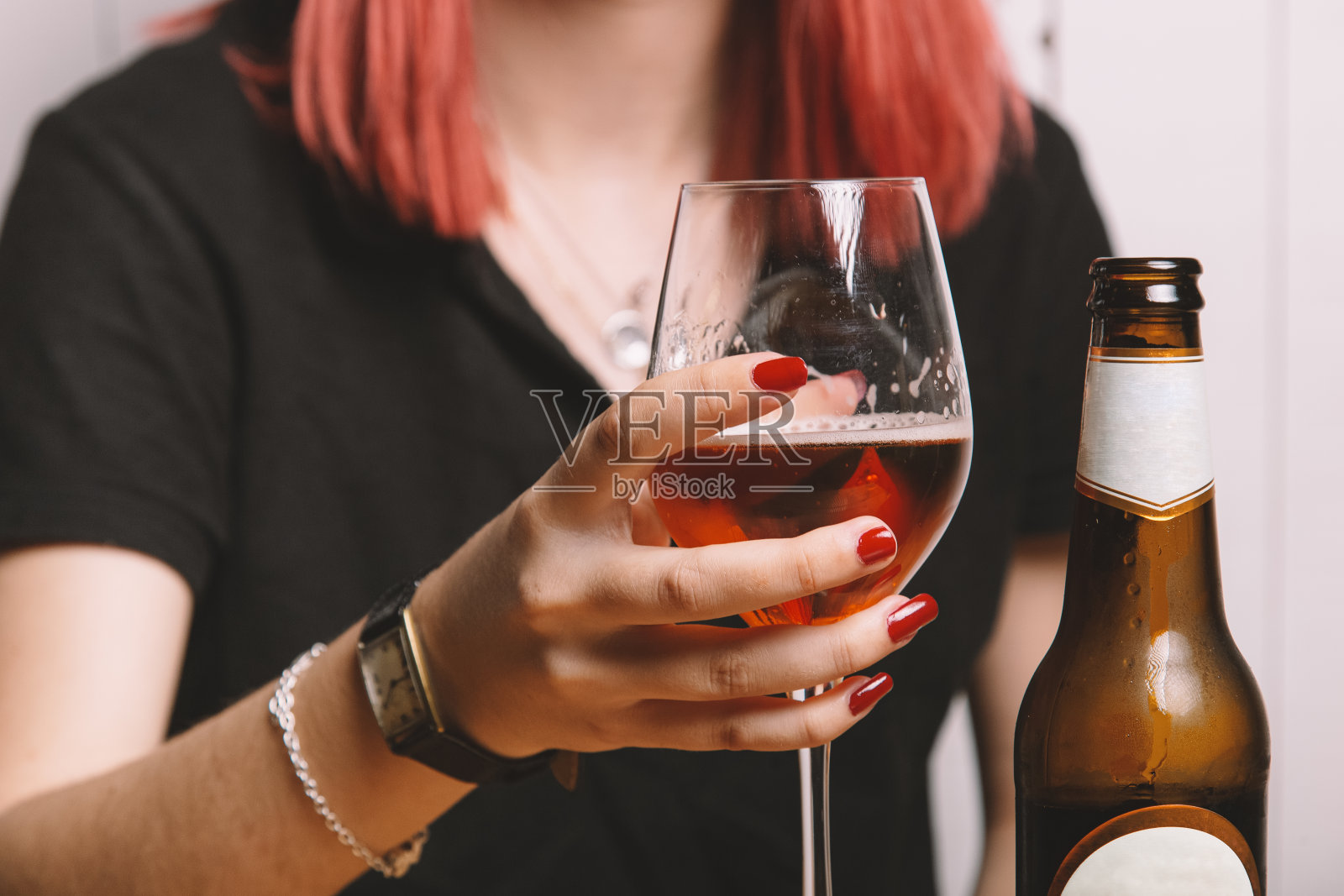 年轻女子喝着啤酒。孤立的形象。照片摄影图片